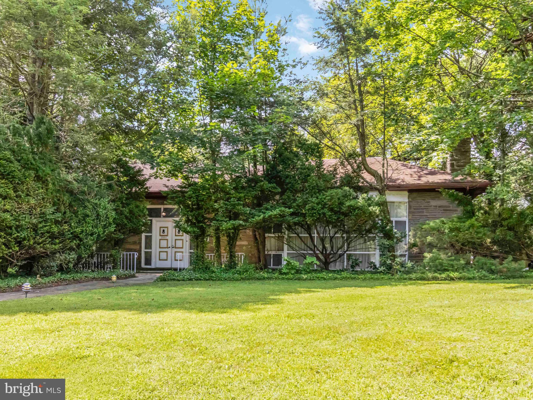 Welcome to 7901 Glen Oak Road, a unique, spacious stone ranch filled with character, nestled in the heart of Elkins Park. This home offers over 5,200 square feet of living space, including a separate 1 bedroom apartment above the detached garage, complete with its own entrance ,full kitchen and bath with separate heating and utilities. Ideal for in-laws, extended family, or rental income annually or as an Airbnb. Inside the main home, you're greeted by a grand double-door center hall entry leading into an expansive foyer. The living room features a full wall of windows, a wood-burning fireplace, and access to a large slate patio perfect for entertaining or relaxing in the private backyard. A separate family room also showcases built-in shelving and access to the patio. All rooms throughout the home are generously sized, including a formal dining room with parquet wood floors and floor to ceiling windows, The kitchen features custom wood cabinetry, a large pantry, gas cooktop on the island, double ovens, built-in desk area, and a large breakfast room. A laundry/mudroom connects to both the kitchen and dining room for added convenience and exterior access. The home offers four large bedrooms, including a main suite with extensive built-ins, a walk-in closet, and a four piece en-suite bathroom featuring a large walk-in shower with multiple shower heads. There are a few steps up to a second level which overlooks the main level and includes a hall bath with double sinks and custom built-in storage in each bedroom. The basement offers abundant storage, a walk-in cedar closet, a large mechanical room with newer central heating and A/C, and access to a crawl space. Additional highlights include central air, a security system with cameras, a backup generator, a slate walkway and patio and a two car garage with electric opener. The home sits on a private lot with driveway access to both Glen Oak and Whitewood Roads. This unique property combines timeless charm, modern functionality, and versatile living space all in one. And there was an appraisal done in June 2025 supporting the asking price. Don’t miss this rare opportunity!