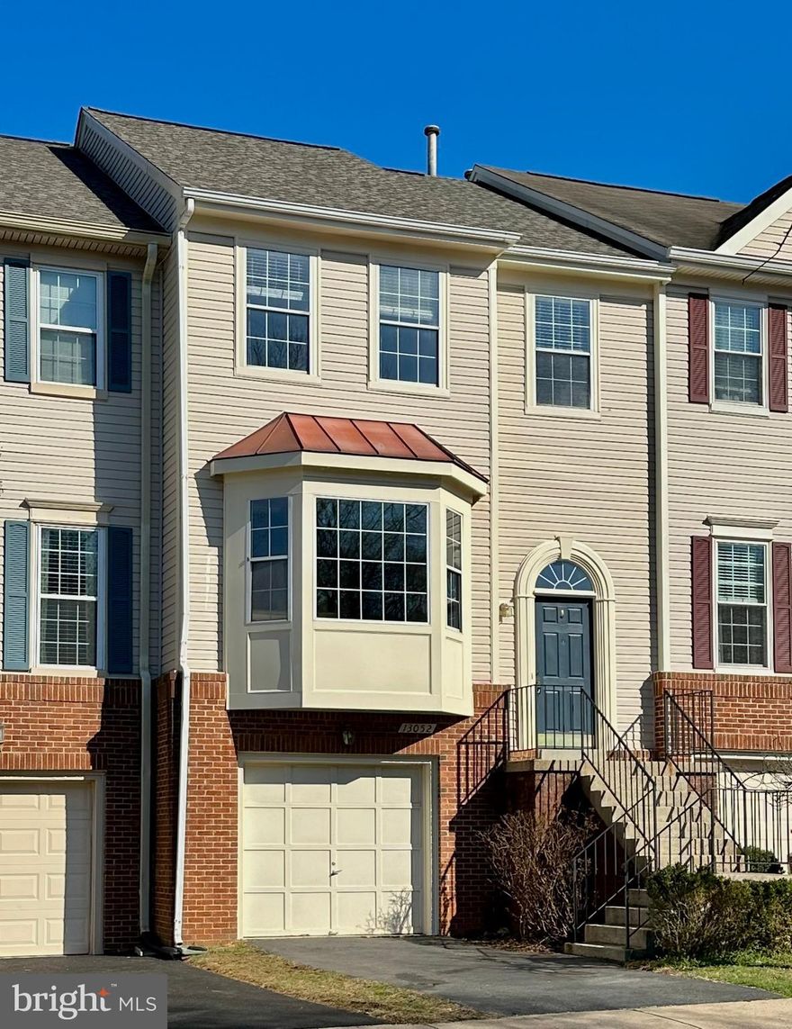 Welcome to 13052 Harvest Place, a beautifully updated townhome tucked within the desirable Rockpointe community in Clifton, Virginia. Offering 3 bedrooms and 3.5 baths, this inviting residence blends modern updates with timeless comfort. A classic brick-and-siding exterior, attached garage, custom deck, and fenced backyard create welcoming curb appeal, while thoughtful interior upgrades—including two fireplaces, designer finishes, and a renovated kitchen—enhance everyday living.
Step inside to discover warm hardwood floors and a light-filled interior designed for both relaxation and entertaining. The main living level features a sunken living room centered around a charming wood-mantel, gas insert fireplace, creating a cozy gathering space. French doors open to a spacious custom deck overlooking the private, fenced yard framed by mature landscaping—perfect for outdoor dining, weekend gatherings, or simply unwinding at the end of the day. Just beyond, the formal dining room offers elegant moldings and refined lighting, setting the stage for memorable meals and celebrations. The adjacent gourmet kitchen combines beauty and function with granite countertops, shaker-style cabinetry, decorative tile backsplash, and quality appliances including a gas range. A tiered peninsula provides convenient breakfast-bar seating and connects to a bright breakfast nook with a bay window that fills the space with natural light. A stylish powder room completes the main level.
Upstairs, the primary suite serves as a peaceful retreat with ample space for a sitting area, a walk-in closet, and a spa-inspired en suite bath featuring a dual-sink vanity, a soaking tub, a glass-enclosed shower, and elegant tile finishes. Two additional bedrooms, each with plush carpeting and generous closets, share a well-appointed hall bath. The walkout lower level adds exceptional flexibility to the home with a second, wood burning fireplace and a spacious recreation area ideal for movie nights, a playroom, home gym, or office. A full bath, laundry closet, and abundant storage enhance the functionality of this level, which can also easily accommodate a guest suite or private workspace.
Life in Rockpointe offers the best of community living with scenic nature paths, an outdoor pool, tennis courts, playgrounds, and welcoming green spaces. Residents also enjoy convenient access to shopping and dining at The Colonnade at Union Mill, Fair Lakes, and surrounding retail destinations. Commuters benefit from easy access to I-66, the Express Lanes, Fairfax County Parkway, and Routes 28, 29, and 50, while outdoor enthusiasts will appreciate nearby recreation including the Virginia Golf Center and the athletic fields and open spaces of Braddock Road Park. Blending classic charm, thoughtful updates, and an exceptional location, 13052 Harvest Place offers a wonderful opportunity to enjoy comfortable living in vibrant Clifton. Welcome home!
