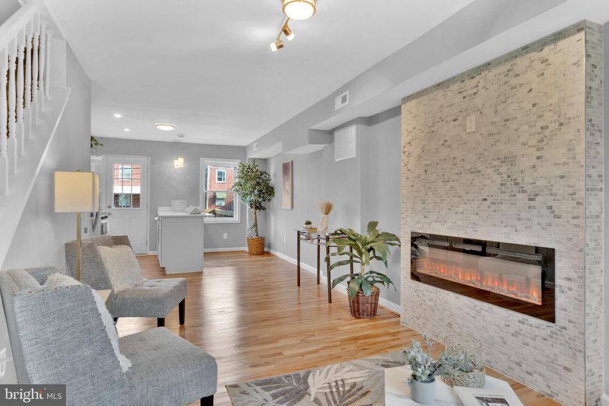 Refined luxury in Belair-Edison! This east Baltimore townhome has been meticulously renovated with care for your peace of mind. Imagine relaxing on your front porch & connecting with neighbors. Enter the front door to an open floor plan perfect for receiving guests. The electric fireplace adorned with floor to ceiling stone tile greets you with style & elevation. Hardwood floors lead you to the open dining area & peninsula kitchen with breakfast bar seating. The stainless appliances & quarts counters glisten under pendant lighting.  Shaker style cabinetry & custom tile back splash finish this space. A rear deck extends the entertaining to the outdoors. Having a lower level primary offers quiet privacy from the rest of the home with new carpeting & private bath. The primary bath is finished in white ceramic tile flooring & tile shower. The lower primary makes immediately washing the stress of the day away as you come home with a direct entrance from your rear parking pad. Upstairs benefits from two spacious bedrooms & a center hall bathroom finished in ceramic tile & tub shower combination. 
Belair-Edison offers opportunity for upscale style & sense of community with neighborhood activities in the park, community events, while retaining easy accessibility to downtown & the surrounding area. Baltimore offers many grant programs for purchasers in the area looking for a home of this style. Have peace of mind with a new roof, HVAC, water heater, & so much more with 3821 Lyndale Ave.