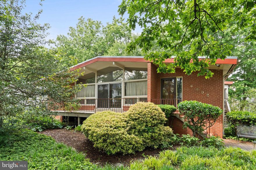 Tucked away on a lush, tree-lined lot in one of McLean’s most sought-after neighborhoods, this spacious mid-century modern home offers timeless style, serene privacy, and abundant potential.

From the moment you arrive, mature landscaping and a peaceful setting create a private oasis just minutes from the vibrant heart of McLean. Step inside to find a welcoming foyer with stone tile and a convenient half bath. The expansive living room features stunning floor-to-ceiling windows that flood the space with natural light and frame tranquil views of the greenery outside. A striking fireplace serves as the focal point, perfect for cozy evenings.

The well-equipped kitchen boasts granite countertops, a wall oven, gas cooktop, and a central island, ideal for cooking and casual gatherings. It flows seamlessly into the dining area and an inviting sitting room, all enhanced by hardwood flooring and skylights that fill the space with light and warmth. Step outside to a large screened-in and covered deck—your new favorite spot for morning coffee or evening entertaining.

The main level includes a generously sized primary suite with a cozy fireplace, large windows, and an expansive en-suite bathroom with dual vanities, skylight, separate toilet and bidet, and a walk-in closet complete with built-ins and another skylight. An additional large bedroom on this level features a walk-in closet and a beautifully tiled en-suite bath with skylight and walk-in shower.

The lower level offers even more living space, including a recreation or entertaining room and two sizable bedrooms sharing a hallway bath. A standout feature is the versatile studio/workshop space located off the rear of the garage—ideal for hobbies such as painting, woodworking, or other creative pursuits. The oversized, side-loading two-car garage adds to the home’s convenience and storage potential.



This special home offers the rare opportunity to enjoy the character of mid-century architecture with the flexibility to personalize. Don't miss your chance to own a piece of McLean’s charm with space, style, and serenity.

Perfectly positioned one mile inside the Capital Beltway, this home offers unmatched accessibility to great Fairfax County schools (Langley HS, Cooper MS, and Churchill Road Elementary), a walking path to McLean Central Park with its new new bandstand, the public library, restaurants, and the McLean Community Center.. And with Dulles International Airport just 13 miles away, Reagan National Airport 12 miles away, and downtown Georgetown only six miles from your doorstep, the best of the D.C. metro area is effortlessly within reach. This is a home where every moment is designed to be enjoyed.