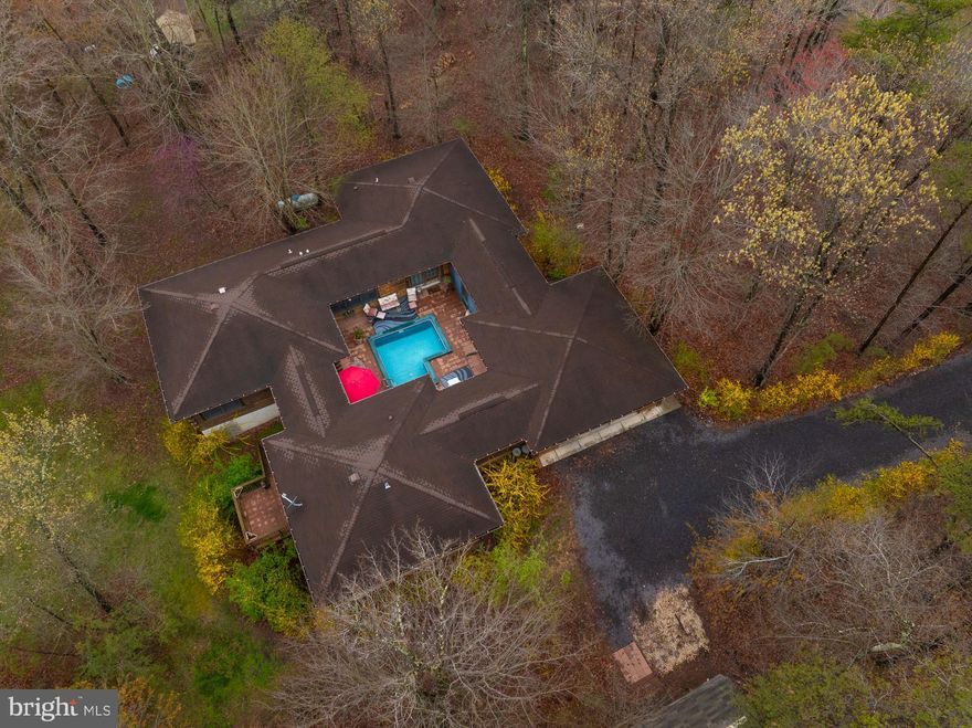 WV THE GOOD LIFE FOR  LESS. An oasis from the ordinary.  Attractive, unique contemporary log home with central courtyard  plus swimming pool  sited on 2.2  wooded acres in a small tree filled community of homes  on large lots with NO HOA.  Comfortable outdoor entertaining.   Great Privacy.  Unique floor plan; home surrounds the exterior in ground  pool.  Home is move in ready.  One level living. Primary bedroom suite.  3 bedrooms, 2 baths.  wood floors, wood ceilings and walls, tile baths, deck,   Large basement.  Lots of storage.   New furnace installed within the last few years.  Full house generator.   Convenient yet private  location in Back Creek Valley  with easy  access to I-81  Close to Martinsburg and Winchester, Virginia.  Minutes to Inwood stores, banks, restaurants, schools.  Carmel is a state road ; maintenance provided.   For commuters  DC Marc train nearby in Martinsburg.
 Low maintenance, easy living.  Escape the hustle bustle.  Quiet, peaceful,  naturally beautiful wooded setting.  Mountain  views.    Please look at the VIDEO TOUR. Click on the full listing a small symbol that looks like a piece of stationary with writing; it will open the documents .  Click on the small rose colored symbol that looks like a camera and it will open the Matterport video tour.   Custom built .    Don't miss this rare one of a kind opportunity.  Only one gets it.