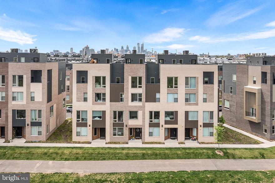 Welcome to 3117 Pierview Lane, a fully upgraded Essex model home in the highly sought-after Northbank community, offering rare, water views along the Delaware River. Unlike many homes in the neighborhood, this residence is perfectly positioned to capture unobstructed river views and an abundance of natural light, creating a peaceful, elevated living experience. Full video tour available—see media section. Enter on the first floor, where you’ll find a versatile space currently designed to function as either an additional bedroom or a private home office, complete with a full bathroom. This level offers flexibility for guests, work-from-home needs, or multi-generational living. Upstairs, the second floor opens into a stunning, light-filled main living area. The open-concept layout seamlessly connects the living room, dining space, and kitchen, all framed by impressive, and open water views. The living area offers ample room for entertaining, while the dining space easily accommodates an oversized table. The kitchen has been thoughtfully upgraded with a waterfall countertop, Wolf gas range and hood, Sub-Zero refrigerator, built-in microwave, stainless steel appliances, and custom roll-out drawers for optimal storage. A stylish dry bar with a wine cooler adds an additional layer of convenience and sophistication. A large pantry and powder room complete this level. The third floor features three spacious bedrooms, each with generous closet space and exceptional natural light due to the home’s unique positioning within the community. Two bedrooms share a well-appointed bathroom with a double vanity, while the third bedroom enjoys its own private en suite. A large laundry room is also conveniently located on this level. The top floor is dedicated to a luxurious primary suite. The bedroom is expansive and serene, paired with a spa-like bathroom featuring a rain head shower and freestanding soaking tub. A custom walk-in closet creates a true dressing space. Just outside the suite, a wet bar leads into a flexible bonus area, perfect for a home office, gym, or additional lounge space, all overlooking sweeping river views. Step out onto the private balcony to enjoy your morning coffee or unwind at the end of the day with the water as your backdrop. Continue up to the rooftop deck, where built-in speakers and panoramic 360-degree views of the city skyline and river create an exceptional entertaining space. This is the perfect place to take in Philadelphia’s skyline, waterfront sunsets, and fireworks. Additional highlights include a two-car parking garage, a private elevator servicing every level of the home from the ground floor to the rooftop, and in ceiling speakers throughout the main living floor, primary suite and deck. While the living room offers a 7.1 channel surround sound speaker system for maximum entertainment. The entire home is finished with upgraded hardwood flooring throughout in a warm, cohesive palette, and is supported by a two-zone HVAC system for year-round comfort. Located along the Delaware River, Northbank offers a unique balance of tranquility and city access, with a waterfront bike path connecting you to the rest of Philadelphia. Just minutes away are some of Fishtown’s most popular destinations, including Suraya, Kalaya, and La Colombe, along with neighborhood favorites like R&D Cocktail Bar and Secondhand Ranch. Experience waterfront living at its finest, with the perfect blend of luxury, comfort, and easy connection to city life. This property has six year left on a tax abatement!