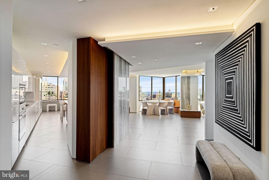 36 oversized windows each overlooking Rittenhouse Square is where you will find this 3,500+ sq ft combined residence. A breathtaking and completely renovated masterpiece by dMas Architects, featuring the building’s iconic ziggurat architecture and 36 oversized windows capturing unobstructed park and skyline views. Every detail has been meticulously curated: hand-plastered walls, sapless walnut flooring, full size travertine and Calcutta Gold marble slabs, backlit quartzite accents, and custom millwork create a luminous, sophisticated sanctuary. The Poggenpohl kitchen is a chef’s dream, with Wolf appliances, Sub-Zero refrigerator and 175-bottle wine fridge, Silestone countertops, floating white lacquer and glass cabinetry, and an island with seating for 4. Walnut built-ins, bowtie-shaped wine storage, and bespoke lighting enhance both elegance and function. The primary suite offers a Sitting Room, dual Offices, dual California closets, complemented by TWO spa-inspired baths with soaking tub, dual Duravit vanities, and porcelain tile. The second bedroom features an en-suite Calcutta Gold marble bath with walk-in shower and floating vanity. Additional highlights include powder room for guests, multiple flexible spaces,  extensive storage, custom electric shades throughout, and integrated audio/visual system. Residents enjoy five-star services and amenities: 24-hour concierge, doorman, valet, chauffeur-driven car, housekeeping, fitness center, spa, indoor pool, and on-site dining at Lacroix, Scarpetta, and Library Bar. This is Rittenhouse Square living at its absolute finest, combining timeless elegance, bespoke finishes, and unparalleled views in one of Philadelphia’s most coveted addresses.