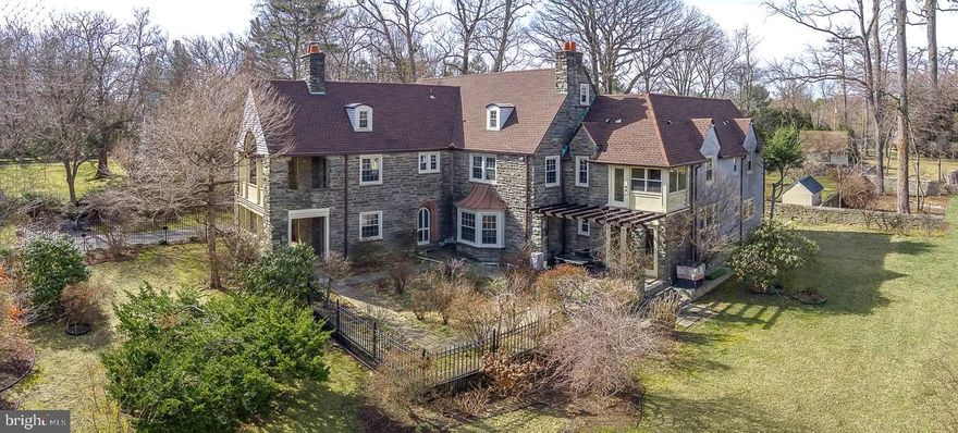 Stately center hall, stone colonial located on a gorgeous flat acre in sought after Wynnewood, Lower Merion Township. This exquisite 6,864 Sq Ft masterpiece has been tastefully updated and boasts 7 Bedrooms, 4 Full Bathrooms, 3 Powder Rooms. Loads of charm and stunning hardwood floors throughout. Enter thru the Center Hall which has beautiful brick floors. Oversized traditional Living Room has lovely French glass doors, large crown moldings, a brick wood-burning fireplace, and access to the stone front porch. Sizeable formal Dining Room has custom built-ins and sunny bay windows. Separate Family Room with custom shelving. Open chef’s kitchen has tons of light, stainless steel appliances, gas stove, double sink, granite counters, and breakfast bar, a Breakfast Room, a separate Sunroom, and Mud Room. Don’t miss the large Pantry and Butler’s Pantry with granite countertops, separate sink, and plenty of storage. There are also 2 Powder Rooms on the Main Level.  The 2nd level contains a breathtaking Primary Bedroom Suite complete with a walk-in closet, a cedar closet, and a renovated Italian tile ensuite with Jacuzzi. Enter into the second bedroom with a stunning stone porch and dressing room. There is also a separate in-law suite with a bedroom, living area, and full bathroom with a beautiful claw tub and laundry area. 2 additional sizeable bedrooms with large closets, 2 full bathrooms, and a bonus closed-in porch with all double-glazed windows and a door. The 3rd floor has 2 bedrooms with vaulted ceilings, a full bath, a cedar closet, and a bonus room. Enormous lower level with wine cellar, Powder Room, and plenty of storage.  The oversized landscaped yard has an Attractive picnic area with a built-in Barbeque grill, a fenced-in tranquil yard, a 2 car attached garage, New Windows. New Roof, New Hot Water Heater, 3 zone Central Air, updated systems. Award-winning Lower Merion Schools, Close to stores, restaurants, shops, and houses of worship. Minutes to Center City and the heart of the Main Line.