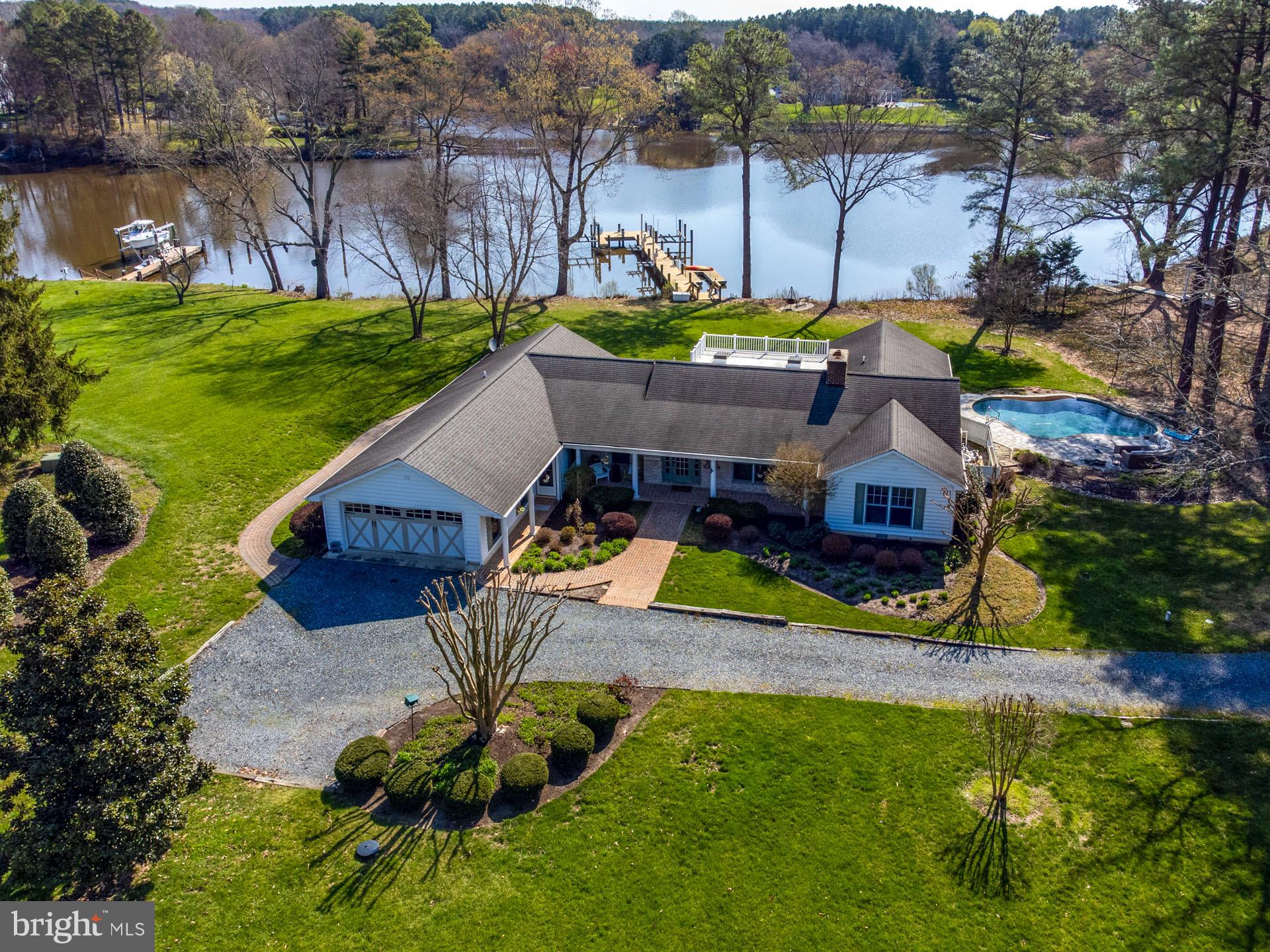 Location, Location, Location!!! This recently renovated waterfront rancher on a 2+ acre, park-like lot is conveniently located next to Talbot Country Club, and off the Oxford Road corridor. This home features 3 bedrooms, 2 full and 2 - 1/2 baths, a large living room with fireplace, kitchen/family room combo with the kitchen featuring quartz counter tops, stainless steel appliances and custom solid wood cabinets. The bedrooms emulate a high-end hotel suite with custom built-in cabinets, tiled bathrooms with incredible zero-entry showers and a steam shower. The sunroom has tile flooring and the garage has a new epoxy floor with a high-end garage "system". This home has had ADA amenity features added making it ideal for buyers looking for "aging in place". Other features include reclaimed barnwood oak flooring throughout the main living areas, a whole home generator, a whole home sound system for movie quality TV audio and music everywhere outside. Exterior features include a waterside pool with infinity edge water feature, stone decking updated pool equipment, irrigated front and back lawn, new 6' wide dock with 2 remote controlled boat lifts, 2 remote controlled jetski lifts, a kayak platform, water and electric and 3' +/- MLW. Property is a nature lovers paradise. It has excellent elevation and beautiful southern views of Trippe Creek where you can watch the Eagles and Osprey nesting in your back yard, as well as a multitude of other wildlife. The colorful sunrises over the creek are a great way to start the day and can only be matched by the beautiful sunsets you can enjoy from your front porch.
