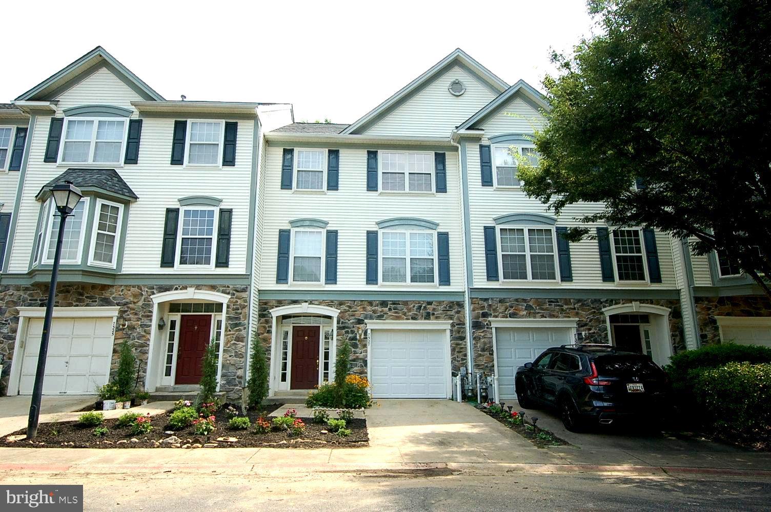 Beautifully renovated from top to bottom, this high-quality townhome spans three finished levels and offers 3 bedrooms, 2 full baths, and 2 half baths. The gourmet kitchen features premium granite countertops, high-end stainless steel appliances, and custom cabinetry, opening to a formal dining room with sliding doors that lead to a private deck—perfect for entertaining. Elegant ceramic tile floors flow through the kitchen and dining area. The bright and spacious living room is filled with natural light and showcases rich-toned hardwood flooring for a warm and sophisticated feel. Upstairs, the expansive primary suite boasts a large walk-in closet with custom shelving and a spa-inspired ensuite (renovated in 2022), featuring a Quartz double-sink vanity, freestanding soaking tub, and a luxurious frameless glass shower with multiple shower heads, all complemented by designer tile and wainscoting. Two additional bedrooms share a fully renovated hall bathroom (2022) with equally impressive finishes. The fully finished lower level offers a generous family/recreation room with a cozy gas fireplace, a convenient half bath, and a large laundry/utility room. Additional highlights include: Spacious 1-car garage with new garage door (2025); Driveway for additional parking; New HVAC system & refrigerator (2023); Roof replaced (2018); Brand new landscaping installed by the well-managed condo association. Tucked away in a serene, tree-covered community, this home offers a peaceful retreat just minutes from major commuter routes, Fort Meade, APL, Columbia Mall, and Dobbin Center. Don’t miss the opportunity to make this exceptional home yours—schedule your private showing today!