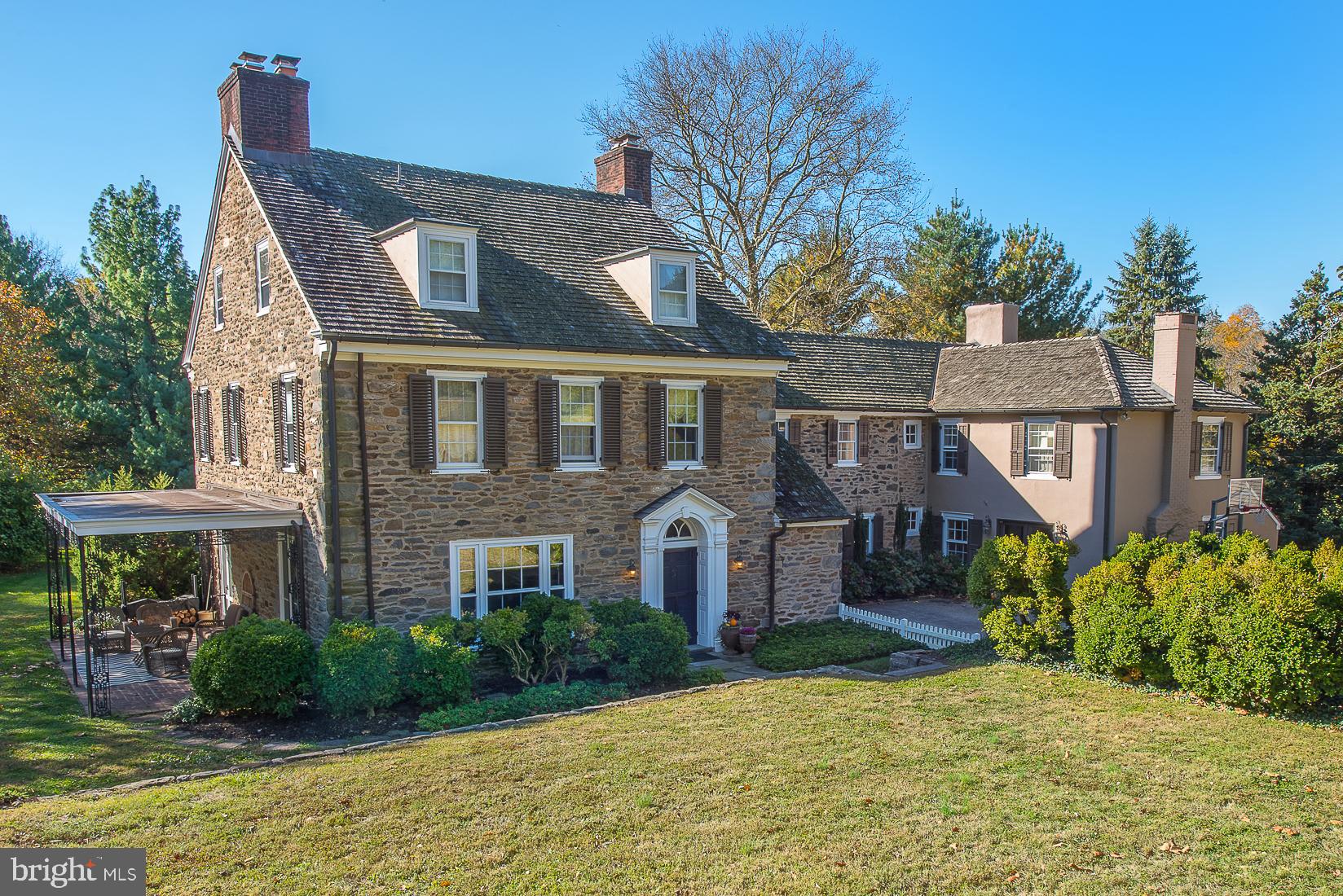 Nestled far back from the road is a gracious Walter Durham stone colonial home, set on 2+ rolling acres. There are 6 bedrooms generously sized , 6.5 baths, and 6 fireplaces. Spacious, light-filled rooms feature wonderful millwork, oversized, original, French doors, gorgeous, random-width, pegged oak floors and deep window sills. In addition to the main home, the property includes a detached 3-car garage/carriage house with a 2-story loft suitable for conversion to a nanny / in-law suite or studio space as well as a charming stand alone root cellar. Enter through the center hall with open stairway to the wood-paneled library, expansive living room and elegant dining room, which all have working, wood-burning fireplaces. A powder room, coat room and service area with wet bar is also accessible from center hall. Kitchen with cherry cabinetry, vintage Delft and Country Floor tiles includes a glass-enclosed breakfast nook and fireplace. Adjacent family room connects to a step-down playroom/au-pair suite with a full bath. The Master bedroom suite on the second floor has an abundance of closet space, a fireplace and sitting room/baby nursery, along with an updated marble bathroom with jetted soaking tub, large glass-enclosed shower and Herbeau fixtures. This floor also has 3-4 additional bedrooms, 3 full bathrooms, a hall linen closet, and storage/ironing room. The third floor hosts 2 large bedrooms with plenty of closets and a full bathroom. This home is a Class 2 Historic property with an original portion built in Circa 1800's. The last addition was constructed in 1939 by Walter Durham. It is rare to find such a classic beauty, carefully updated to meet the needs of today's family. One year Home Warranty comes with purchase of home!