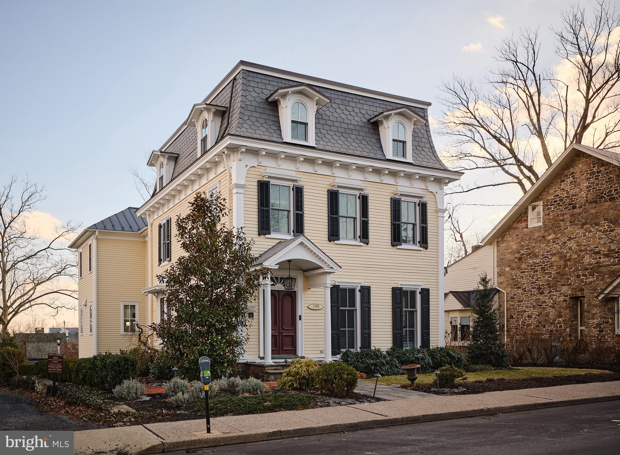 Historic charm blends seamlessly with sophisticated modern luxury. Welcome to 148 E. State St. Located in the heart of Doylestown Boro this stunning Victorian is a lovely example of Second Empire architecture from the mid-1800's with its mansard roof and dormer windows. This four bedroom, 3.5 bath property went through a major renovation and expansion in 2019, taking great care to incorporate the historic characteristics that make this home so unique. A large two story addition in the back expanded both the second floor primary bedroom and the first floor kitchen, adding a large pantry and mud room with access to a partially covered blue stone patio providing ample space for outdoor entertaining. The gourmet kitchen boasts high end appliances, a large island with storage and microwave, a dining area with a bow window and a separate seating area. Just beyond the kitchen is a staircase leading to the lower level. The finished portion provides ample space for a family room. There are built-ins with a sink and wine fridge. On the other side is the mechanical room with extra storage. As the house has been wired for sound there is an electronics container to house equipment. Walk past the stairs into the long dining room with a gas fireplace and wet bar. Beyond that is the living room where you can enjoy the wood fireplace. Both fireplaces feature mercer tile. There are two bedrooms on each of the upper floors. All four bedrooms are oversized and all baths have been remodeled. The primary suite has a seating area surrounded by a bow window. and two large walk-in closets. The luxurious bath has double sinks, a large shower, a soaking tub and radiant heat in the floor. The second bedroom has its own bath and a large walk-in closet. The two bedrooms on the upper floor share a hall bath and both provide ample closet space. There is an oversized two car garage to the back of the property with a dedicated driveway to Church St. and an enclosed entryway off the patio. Recent improvements include electric car charging stations on both sides of the garage, the installation of a/c on the upper floor, a whole house water softening system and, in 2024, the installation of an elevator that provides easy access to all four floors. In 2023 the exterior went through extensive remediation with a historic home specialist to remove lead paint, replace wood that had rotted as well as a portion of the copper roof, after which all was repainted. This work earned an award from the Boro for returning the home to its current pristine condition. Enjoy the beautiful landscaping and exterior lighting as you relax on the patio or stroll into town to enjoy all that Doylestown has to offer. Sunday Open House is cancelled due to property being under agreement.
