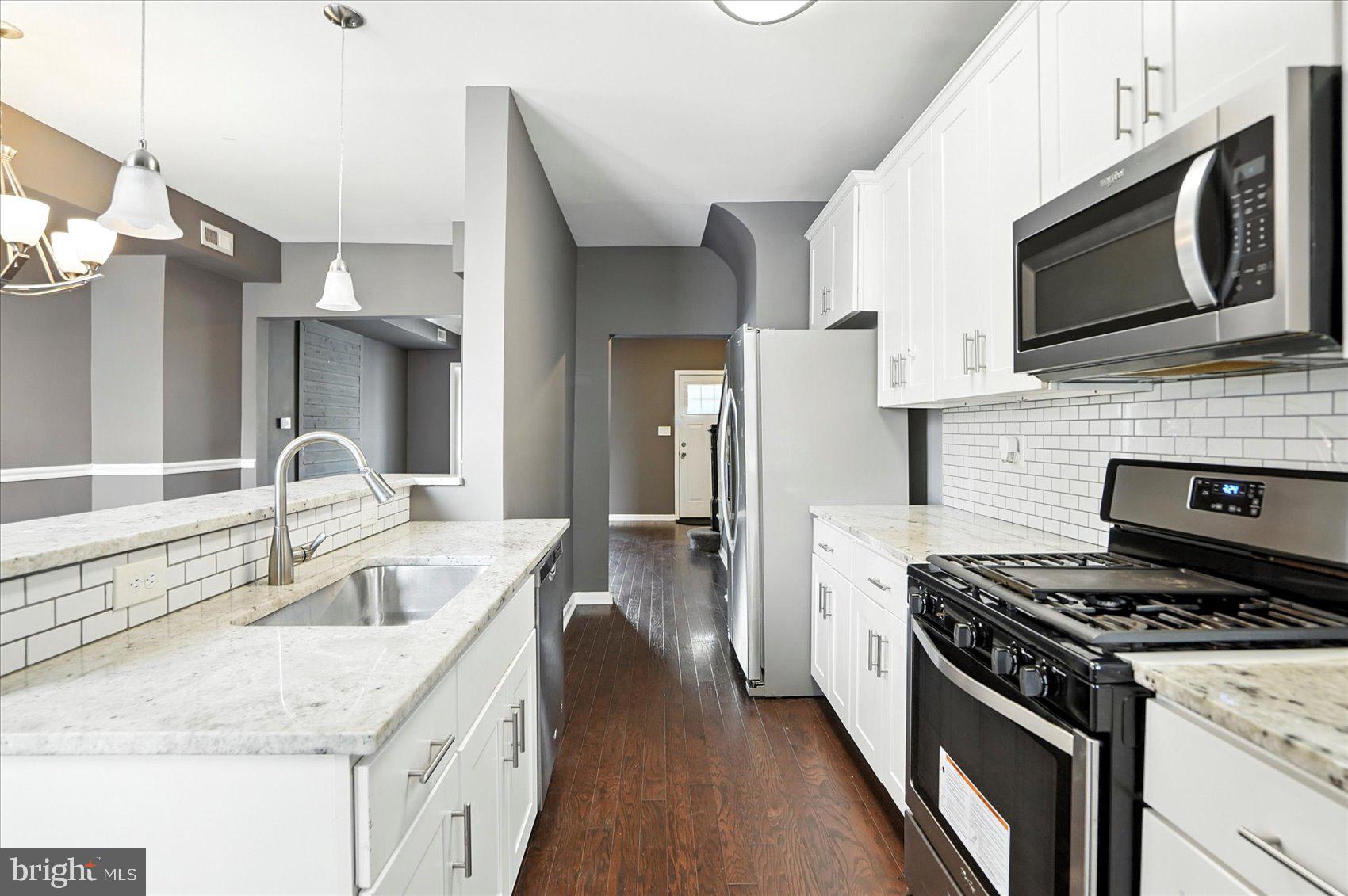Beautifully remodeled 4BR/2BA Townhome located on a tree-line street. Make your way through the gated front yard offering tons of green space on your way to the front door into your new home. Step inside to a home filled with natural light, hardwood flooring, a freshly painted interior, and an open floor plan. The main floor features a spacious living room with french doors to the enclosed sunroom ideal for a home office, a spacious dining room with chair rail moldings, and a beautiful kitchen. The kitchen features plenty of cabinets finished with crown moldings, stainless steel appliance, granite countertops with a subway tiled backsplash, a walk-in pantry, and a deep sink under a raised breakfast bar with seating for three or more. On the second floor are two sizable secondary bedrooms, a large primary bedroom, and a newly remodeled full bath with a jetted soaking tub surrounded by stunning tile. The lower level is finished offering additional living space featuring the fourth bedroom, a full bath with a beautifully tiled tub surround, laundry, storage, place for the family to gather, and a walk-out to a Bilco door in the yard. From the kitchen, step outside to a semi-fenced yard with green space, a parking pad, and tons of possibilities. This home is move-in ready with so much to offer new homeowners and is located in close proximity to shopping, restaurants, and commuter routes.