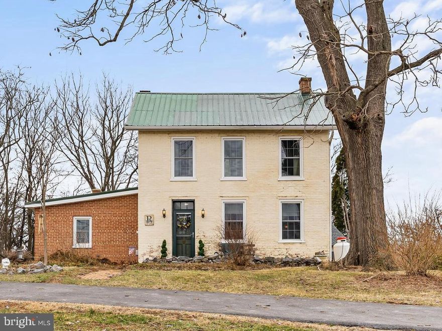 Here is your chance to own a farmhouse with historic charm and modern comfort situated on just under an acre in Williamsport.  You are immediately greeted by inviting gardens with plants ready to burst with Spring flowers.  Step inside and Sunlight spills through large windows, (windows updated within the past 3 years), highlighting the rustic wood floors and thoughtful details that make this home truly special. The living room has a fireplace that has been updated with a propane gas insert. The separate sitting room has timeless appeal with a vintage parlor stove which is both decorative and functional and just perfect for curling up with a book on chilly evenings.  The well-appointed kitchen boasts farmhouse-style cabinetry, ample counter space with granite countertops, Stainless Steel Appliances and an island. The dining space is open to the kitchen and is truly a welcoming atmosphere that invites gathering and conversation.  Laundry is just off the kitchen.  Upstairs are three bedrooms, two walk in closets and a full bathroom.  The attic offers plenty of storage space.  A large screened-in porch is a private space to enjoy quiet moments throughout the day and is large enough for guests to enjoy.  Then, step outside to discover a charming brick patio, that leads to a separate detached Summer House or Studio, offering endless possibilities—an artist’s retreat, a writer’s hideaway, or even a private guest suite. An original stone smokehouse just had a new roof installed last year.  This home is surrounded by nature and is a rare gem that offers both tranquility and inspiration. Whether you dream of a small homesteading opportunity, or a creative space, or simply soaking in the beauty of country living, this home is ready to welcome you.  And, it is convenient to Interstates, the C&O Canal is within walking distance, and shopping and dining are all nearby!  Don’t miss your chance to own this one-of-a-kind home. Schedule a showing today and experience its magic for yourself!