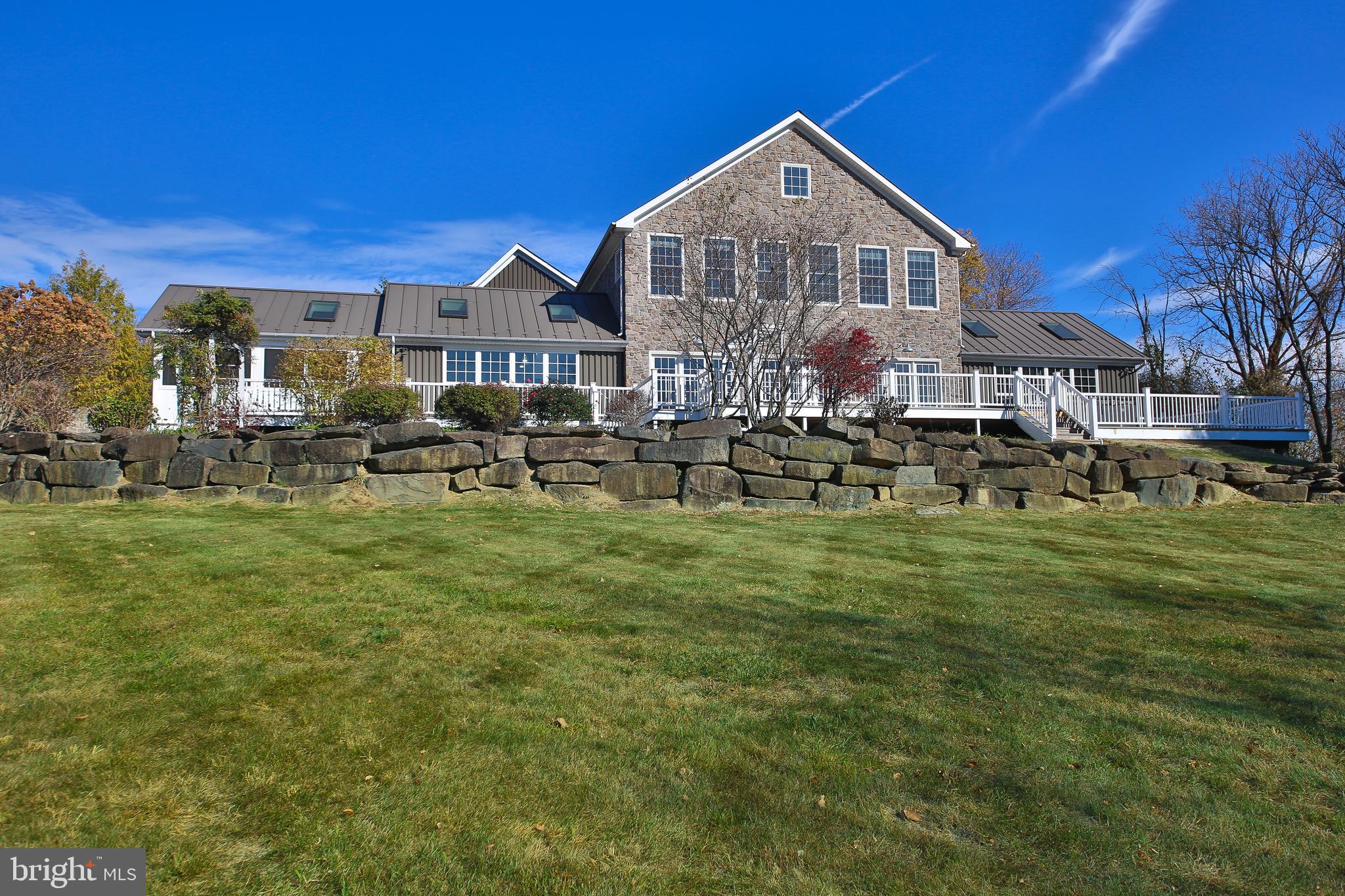 Welcome to 91 King Rd, a 5 bedroom dream home overlooking the serene Lake Galena, where modern elegance meets charming farmhouse touches. Foyer leads into the captivating grand room, with stained and sealed limestone flooring with radiant heat, and expansive window walls that flood the space with natural light. This remarkable area, perfect for hosting gatherings, features built-in shelving, electric fireplace, track lighting, and exposed ducts and beams. Doors open to a newly stained deck, where you can enjoy the breathtaking views of the peaceful 2.6 acres surrounding the property. The chef's kitchen is a culinary masterpiece, with abundant lighting and skylights, granite countertops, two ovens, and two dishwashers all complemented by a full pantry. From the kitchen, you'll access a newly updated screened-in porch, perfect for enjoying the outdoors or entertaining. The primary bedroom suite on the first floor has neutral carpeting, skylights, a spacious walk-in closet, a laundry room, and an en suite bath and shower. Rounding out the first floor is a conveniently located powder room to accommodate guests. Upstairs, there is a newly added in-law suite with walk-in closet, bathroom with soaking tub and stall shower, and also features a private balcony and steps to the backyard. Floor also has three generously sized bedrooms with laminate flooring, one bedroom has en suite bath, while the others share a hall bathroom. There is also a hall laundry room. The home has a three-car garage for all your storage needs. Tastefully maintained and updated, this property offers the perfect blend of privacy and natural beauty while being conveniently located less than 10 minutes from Doylestown Boro, with a wealth of shopping, dining, and golfing options. Don’t miss the opportunity to call this extraordinary property your home!