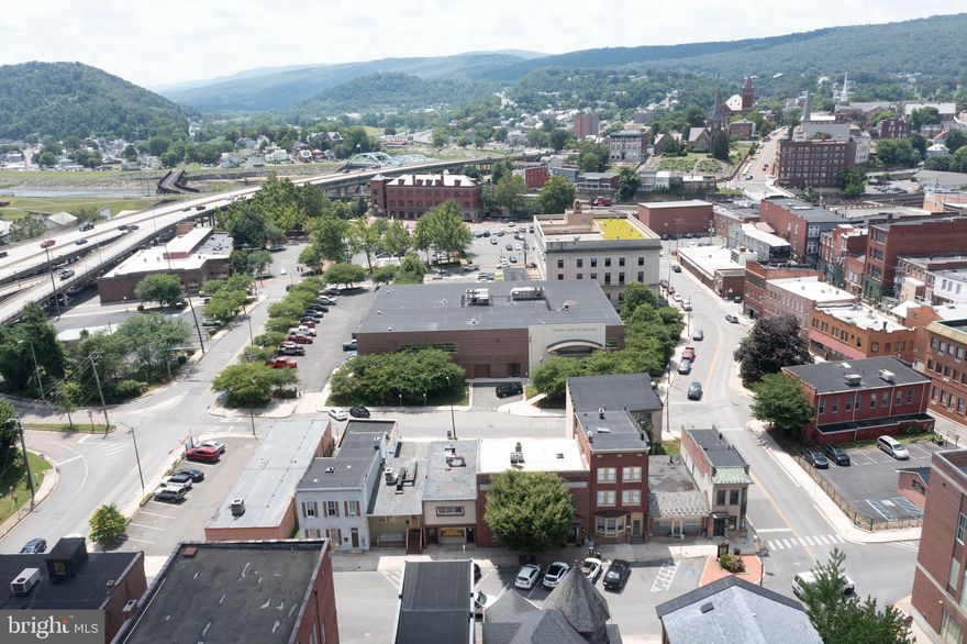 This is a once in a lifetime opportunity to capture the all-new downtown vibe in Cumberland, Md in its infancy! Situated just steps from the A&E district offering restaurants, art galleries, nice stroll to the historic district, live entertainment, coffee shops, and shopping, and you are right in the in the" now" of what's happening! From the outside it reminds you of possibly Williamsburg  or Oldtowne Alexandria with its shady trees and colonial appearance--but inside, there is no other way to put it---this building is pure funk!! Decorated creatively in an industrial motif by the owners, with their ingenious appreciation of this impressive space , they adorned it with bookshelves and beautiful hardwoods all ideal for your interesting collections, large walls ready for your most beautiful art, and an amazing gourmet kitchen ideal for entertaining, this is  undoubtedly a step above the rest for this area. As for a professional, downstairs is ideal for your business and the upstairs is your place to entertain , enjoy, and just kick back with some jazz, cigars, and bourbon... and then whenever you decide, you will be right in the sweet spot of the city!  Just steps from the courthouse, a few "pedals" to the bike trail, short jaunt to the Scenic Railroad, and less than a minute to I-68 e & w, if that isn't enough to pique your interest, this property has something almost ANY other downtown site would covet---it has a 4-5 space parking lot in the back.  Think also of an undeniably fabulous air bnb or two separate  income producing units. Wow--this is one you do not want to miss! Priced to sell quickly--don't miss the Matterhorn 3d tour included in this listing.