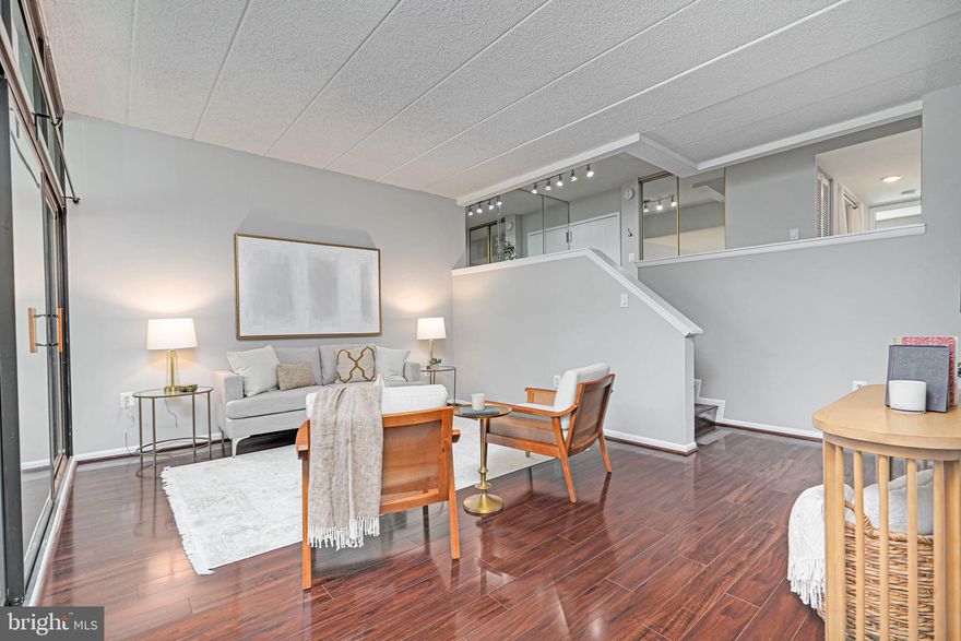 Welcome to your beautifully remodeled 2-bed/2bath condo, where modern updates meet serene natural surroundings. Enjoy the feeling of being nestled in nature with floor-to-ceiling windows offering stunning views of lush trees and greenery.  Inside, a few stairs expand the living/kitchen/dining area into stunning high ceilings where wood floors extend throughout,  there is a private balcony ideal for relaxing, and the modern kitchen features updated appliances. The primary bedroom includes ample closet space for all your storage needs.  Completely painted throughout in 2024.  HVAC system was updated in 2023, ensuring year-round comfort. Conveniently located near scenic trails, a peaceful creek, and a golf course, with easy access to the Silver Line Metro, public transportation, Reston Town Center, the Toll Road, and Fairfax County Parkway. Enjoy one reserved parking spot and ample visitor parking. Condo fees include water for hassle-free living. Don't miss this opportunity to call this tranquil, modern condo your new home.