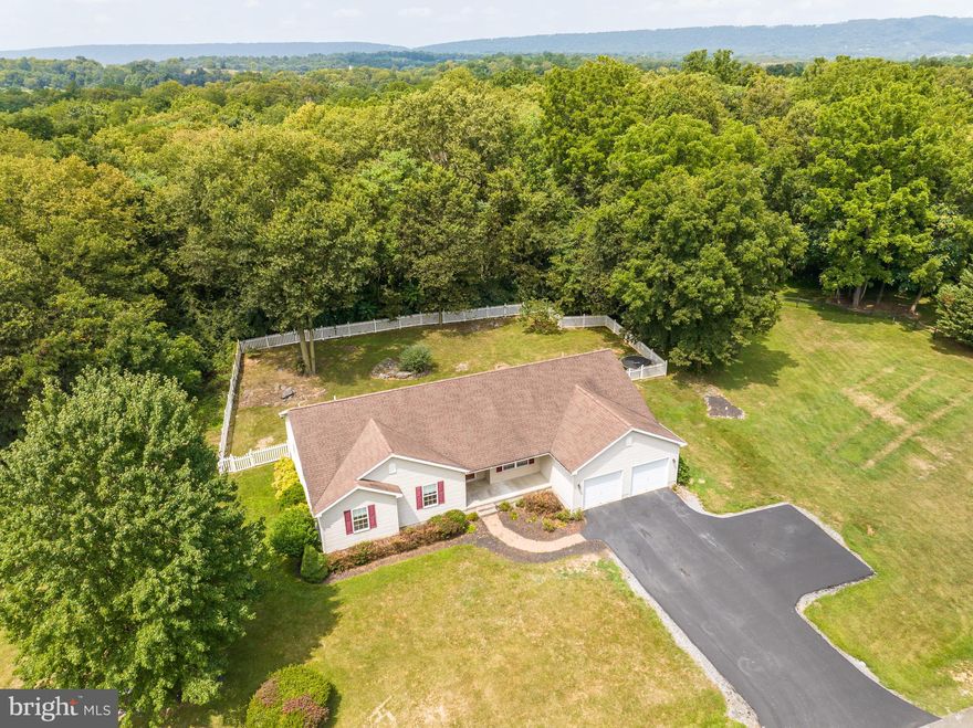 Welcome to a piece of heaven in WV! 3 bd/2.5 bath in a sought out area is a one of a kind. The home boasts of almost 2200 sq feet on one level. Walk into foyer area from front porch with views to the family room and kitchen. Family room is large and open to the kitchen with island. Separate mud room with laundry area and powder room between kitchen and garage. Large bonus room behind garage and off of kitchen and is fantastic for a home office or game room. Walk out to back patio from family room area. Bedrooms are private from the main living areas. Primary bedroom features walk-in closet and en suite bath with dual vanity, soaking tub and separate shower with new flooring . Two secondary bedrooms are spacious and share a full hall bath. LVT throughout entire home. 2-acre lot is a dream and backs to trees for tons of privacy. Portion of backyard is fenced in with vinyl picket fence. Garage has extra storage room, pull down access to attic and service door. Fresh paint 2023. Don't miss this one!!