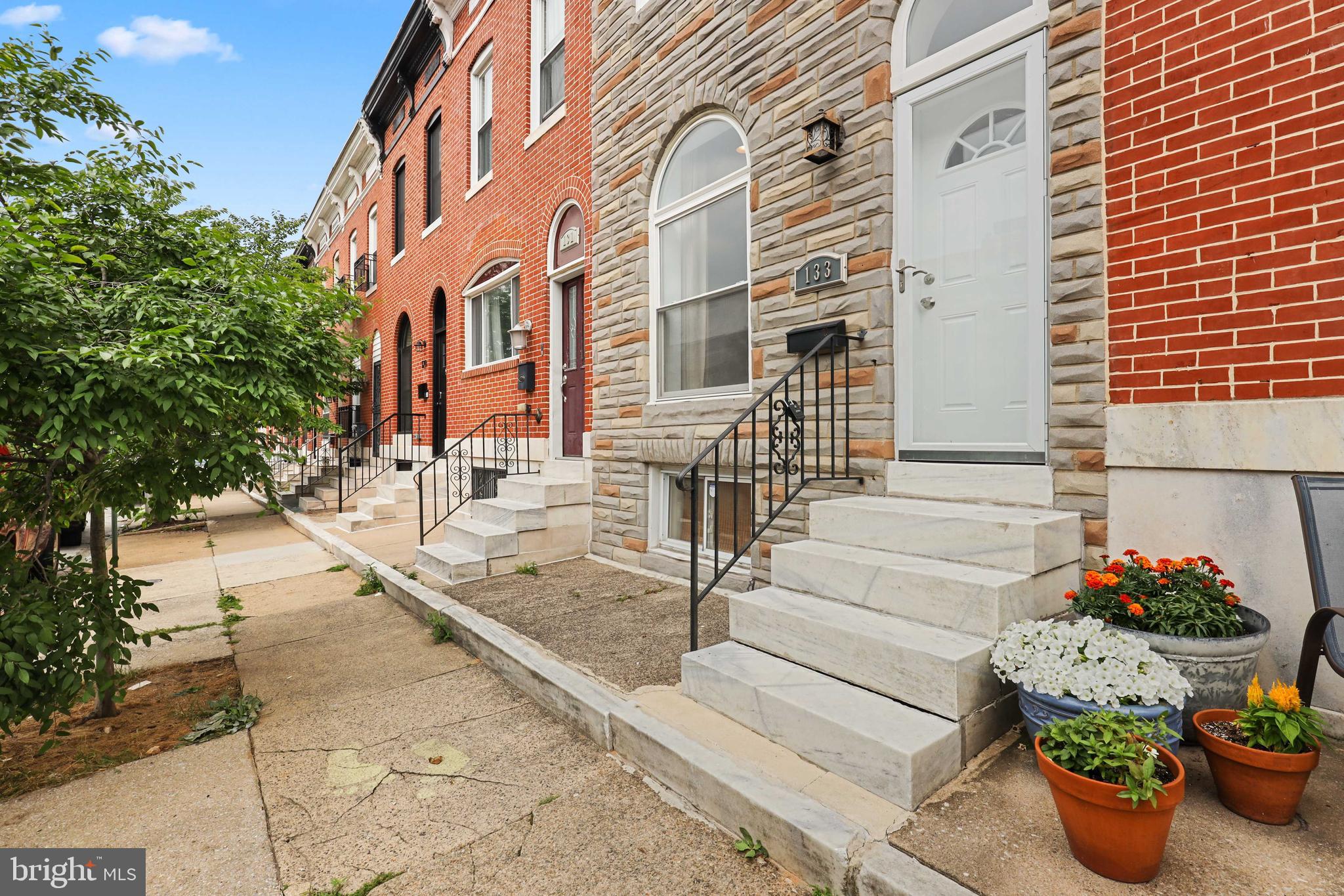 Beautiful home on tree lined street close to Patterson Park! Spacious entry level with living room, dining area, exposed brick, bamboo floors, high ceilings and recessed light. Great kitchen space with peninsula for additional seating and wet bar. Upper level has primary bedroom with en suite bath with stand up shower, second bedroom and hall bath. Finished lower level with bar and half bath. Privacy fence in rear with patio areaa.