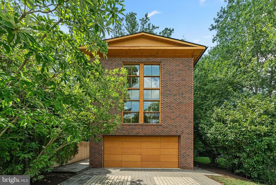 Architecturally stunning. Naturally bright. Perfectly placed.
Welcome to 2504 Buckelew Drive—an award-winning, custom-designed contemporary residence just a short walk to West Falls Church Metro, yet quietly tucked into a peaceful, tree-lined enclave near the W&OD Trail.

This Energy Star Certified home blends minimalist European aesthetics with intentional, light-filled design. Crafted to maximize sunlight throughout the day, it features floor-to-ceiling windows, multiple skylights, and a striking modern staircase accented with reclaimed wood slats that run from ceiling to basement—a beautiful marriage of form and function.
At the heart of the home is a stunning living room with soaring windows, a ventless gas fireplace, and three sets of French doors that open to a private terrace surrounded by greenery—creating a showstopping space that’s both warm and impressive, perfect for entertaining or unwinding in style.

The open-concept main level flows effortlessly into a gourmet chef’s kitchen featuring quartz countertops, high-end appliances, and clean-lined cabinetry. Maple wood floors run throughout the home, enhancing the cohesive, contemporary aesthetic.

Upstairs, the luxury primary suite offers a serene retreat with a spa-inspired bath and a skylight above the shower—an everyday indulgence. The mezzanine level features dual office spaces, ideal for working from home or flexing into a playroom or creative studio. The expansive finished lower level includes a full bath, rec room, gym, and generous storage space.

Additional highlights include a generator, irrigation system, custom built-ins, and energy-efficient systems throughout.
All just steps to the W&OD Trail, neighborhood strolls for ice cream, and minutes to Tysons, Mosaic, parks, dining, and commuter routes—yet offering a level of privacy and tranquility rarely found this close-in.  Plus award winning schools! 

This is more than a home—it’s a lifestyle designed for those who value clean design, natural light & purposeful living.