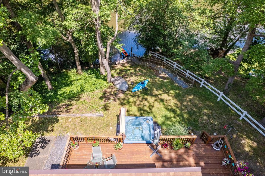 Serenity surrounds you! This 1/3 acre, secluded 2 BD 2 BA waterfront stone front home has an expansive deck that awaits you, with plenty of room for a variety of deck seating, maybe even a swing!  You can grill, enjoy friends and family, relax in the included hot tub while watching the sunset, or just have alone time and watch the wildlife and the peaceful water views from the comfort of your own deck. 

As you walk into the home, the living room will welcome you with a spectacular view of the water with several large beautiful windows.   The vaulted ceiling and the large stone wall fireplace also add to the ambiance to enjoy the views of the creek, trees, and sunsets.  Once outside off the deck, you take steps down to the water where you can stop at a lovely sitting area to relax and enjoy the view or take a canoe or kayak out on the creek, which leads out to Magothy River.  

 The house is just a few miles away from Down’s Park, which has great walking/biking trails and is located on the river, and the Pavilion in the park has summer entertainment.  So much to choose from!

There is a pellet stove that was installed in 2010 for those colder months. Your heating bills will be lower due to the warmth provided by the pellet stove. The pellet stove and bags of pellets stay in the home. There is an included pellet stove vacuum as well.

Other features include kitchen updates, lighting, a new roof in 2020, a newly asphalted driveway in 2018, a carport installed in 2016, a shed, a 220v hot tub in 2016, and new laminated plank honey oak flooring throughout, except in the living room.  A new kitchen window above the sink just installed on 5-31 !!

The main bedroom suite is very large with new carpet, a large sunken tub, and a new bathroom countertop.  Natural light abounds from the large windows.

The well water treatment system was replaced in January of 2022, and several salt bags will be left for the new owners. 

There is a very nice stone floored breezeway with storage. The breezeway can also be used as a mudroom.

The dining area has a kitchen nook with a great dinette set that fits perfectly, and that stays as well.  In the galley kitchen, there are two roll-out windows that look out at the creek while you’re washing your dishes. 

There is a Petro annual service agreement for the oil tank and HVAC system that will transfer to the new owner(s).  This includes yearly maintenance and cleaning of the units.