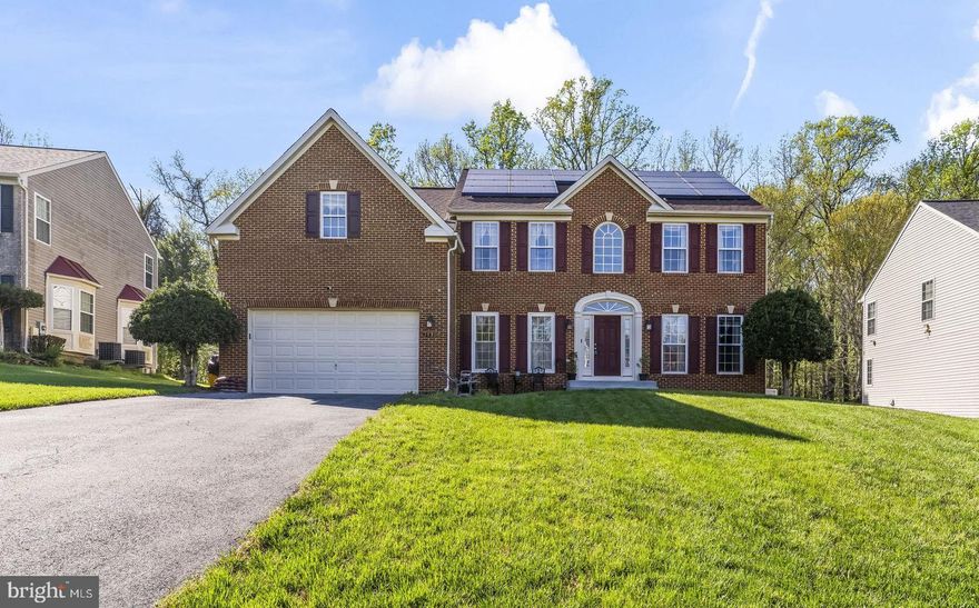 Welcome to this impressive brick-front Colonial offering a spacious and well-appointed layout, enhanced by a newer roof, dual HVAC systems, and a Generac natural gas backup generator for added peace of mind. From the moment you arrive, the resurfaced front porch and walkway, along with professional landscaping, create strong curb appeal. Inside, a dramatic two-story foyer with hardwood floors and a turned staircase opens to a thoughtfully designed main level featuring 9-foot ceilings, a private office with French doors, and elegant formal living and dining rooms with hardwood flooring, custom trim, and refined finishes.

The heart of the home is the expansive island kitchen, beautifully appointed with granite countertops, 42-inch cabinetry, stainless steel appliances including a double wall oven, built-in microwave, JennAir gas cooktop, and a spacious pantry. The adjoining breakfast nook with tile flooring offers direct access to the large screened porch, while the open layout flows seamlessly into the sunken family room. Here, a 2 story vaulted ceiling, transom windows for abundant natural light, and a gas fireplace with marble surround and wood mantle create a warm and inviting space, complemented by a convenient rear staircase to the upper level.

Upstairs, the luxurious owner’s suite features double-door entry, an octagon tray ceiling with indirect lighting, a generous sitting area, and 2 large walk-in closets. The renovated en-suite bath offers dual granite vanities, an oversized soaking tub, and a glass-enclosed multi-spray shower with designer tile. Three additional bedrooms, all with ceiling fans and ample closet space, share a beautifully updated hall bath. The fully finished basement provides exceptional versatility with a large recreation room, sunken entertainment area, full bath, and a flexible room ideal for a gym, theater, or guest space.

Outdoor living is equally appealing with a 15x21 screened porch addition featuring vaulted ceilings, stamped concrete flooring, and LED lighting, along with a covered patio and additional outdoor space backing to mature woods for privacy. A storage shed, floodlights, and access to a community walking path enhance the setting. Convenient  access to nearby amenities, this home offers a perfect blend of comfort, function, and lasting value.