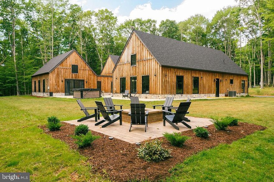 Welcome to Big Bass Lodge — a show-stopper retreat nestled in the heart of Maryland’s forested splendor near Deep Creek Lake. This expansive 4,300+ sq ft  estate sits on over 8 serene acres along the Youghiogheny River, bordering state ground and offering complete privacy, end-of-road access, and over 1,420 feet of river frontage that blends seamlessly into a wild-scenic state park setting. Designed for both grand gatherings and intimate escapes, the home features 4 bedrooms, 3.5 baths, and flexible layouts including a 900 sq ft loft/flex space with 3 twin beds. Unwind in the spacious hot tub for six, gather around the custom firepit, or launch games of bocce or cornhole under the treetops. Inside, a gourmet kitchen sets the stage for entertaining, while a large game room with wet bar, darts, poker table, and shuffleboard keeps energy high. The primary suite is a sanctuary unto itself — with walk-through closets, sweeping views, and even a ceiling design framed by the moon and stars. Thoughtful amenities abound: central A/C, high speed streaming, wide doorways/step-free access for accessibility, and sleeping setups that accommodate large groups (king, queen, bunks, twins, roll-aways). Minutes from Deep Creek Lake, Wisp Ski Resort, riverside trails, and golf courses, this is not just a home — it’s a legacy property, a high-end vacation asset, and a nature lover’s dream. Seize the opportunity to own a piece of Maryland’s most captivating landscape and lifestyle.