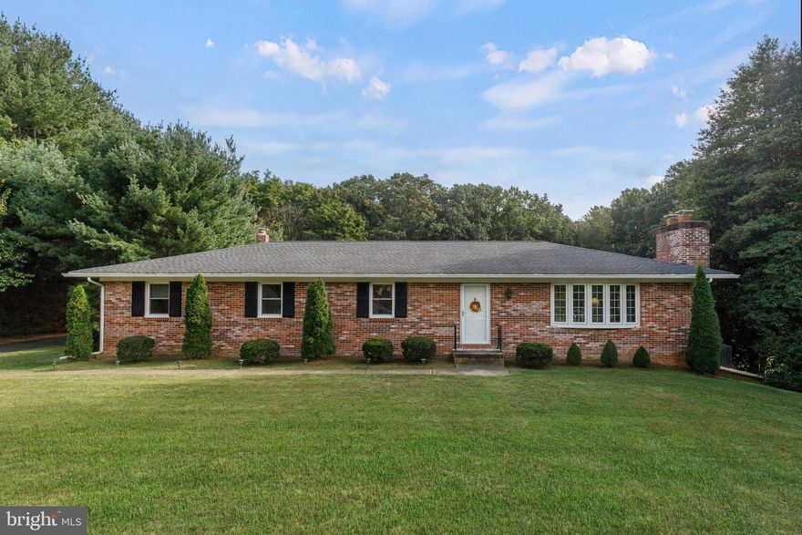 All brick rancher situated on a picture pretty 2.26 acreage backing to Pretty Boy.  This home exudes pride of ownership by the original owner! The Kitchen has been updated with Quartz counter-tops and Stainless steel appliances.  Many important updates:  Architectural roof "2018", 33 x 12 Trek Decking "2019," heat pump "2022" with back up oil heat, Oil burner was completely rebuilt "2023" double oil  tank "2023," hot water heater "2021," leaf guards  & gutters "2013," and the baths were updated in "2014."  Beautiful bow window in the living room and dining room which allows for an abundance of natural lighting. Gleaming wood floors! Beautiful Stone fireplace in living room was built by Watson's Fireplace in 2015. The lower level has a huge family room w/wood burning stove, utility room, storage room and a walk-out to the rear yard. For those who enjoy tinkering with projects or working on cars, there is a large three bay outbuilding.  At one time there was electricity in the outbuilding, however, the electricity has been disconnected. In one of the bays there is a concrete pit 5 1/2 feet deep, 3' wide by 7' long, the seller enjoyed working on his cars. If this home fits your needs and your budget, you would be hard pressed to find a more meticulously maintained home with a breathtaking 2.26 acres backing to Pretty Boy in the Hereford zone!