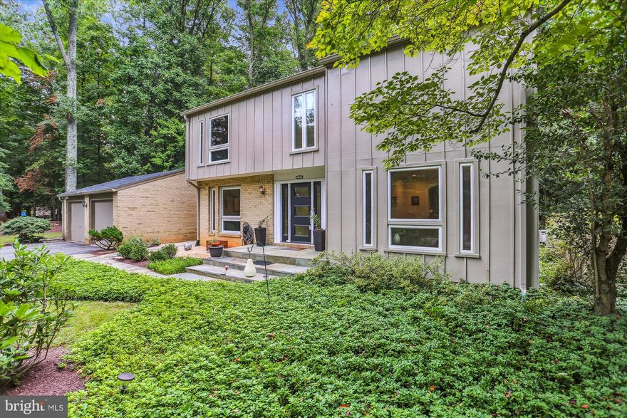 The updated Mid-Century modern home on a tranquil cul-de-sac, nestled against a backdrop of lush woods, seamlessly marries the timeless elegance of mid-20th century design with modern comfort and functionality. This home is a testament to the enduring appeal of the Mid-Century modern aesthetic while accommodating the demands of contemporary living. The exterior of the home retains the clean lines and minimalist charm that define Mid-Century modern architecture. The façade features a harmonious blend of wood, brick and glass, with large windows that offer picturesque views of the surrounding woods. Upon entering, you are greeted by an open-concept living space that seamlessly combines the living, dining, and kitchen areas. The heart of the home is the living room, which boasts a vaulted ceiling with natural wood ceiling, an original freestanding, cone fireplace next to the almost floor-to-ceiling windows that flood the space with natural light. These windows frame the serene woodland view, making it feel like an ever-changing work of art. The kitchen is a chef's dream, featuring modern appliances seamlessly integrated to make the chef's job easy and enjoyable. The countertops are made of durable and elegant quartz, and a large built-in waterfall table for casual dining. The bedrooms continue the theme of clean lines and ample natural light. The primary bedroom suite is a spacious oasis with its own sitting area duplicating the natural wood vaulted ceiling from downstairs. The ensuite bathroom features double sinks, including a deep soaking tub and a walk-in shower. The 3 Additional bedrooms have all new carpet, with hardwood underneath. The lower level is a perfect spot for relaxing and play, complete with a full bath and laundry area. The back of the house opens to an expansive deck, seamlessly merging indoor and outdoor living. This space is perfect for entertaining or simply enjoying the tranquility of the woods. Mature trees provide shade and privacy, and a well-manicured lawn offers a space for outdoor activities. A detached garage offers space for 2 cars and direct access to the kitchen.  Located in the award winning  Churchill HS cluster. Join the TallyHo Swim and tennis club and walk out the back door and across the field to swim!