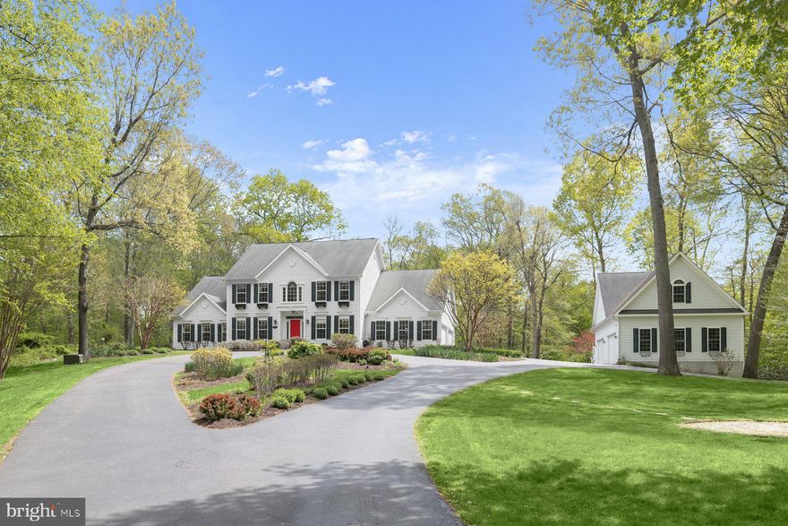 Nestled deep within a tranquil, wooded setting, this exceptional residence offers privacy, elegance, and a circular driveway leading to a stunningly renovated home by a renowned contractor known for exceptional craftsmanship. Thoughtful updates include a gourmet kitchen, a luxurious primary bathroom with marble finishes and a steam shower, a gas fireplace, and gleaming hardwood flooring throughout the main level. Additional noteworthy renovations include the rear covered porch, extensive hardscaping, HardiePlank siding, and an impressive detached four-car garage with soaring ceilings, a lift, and a loft, with plumbing - bringing total garage capacity to 8+ vehicles between the two, four car garages. Beyond parking, this versatile structure offers endless potential as a workshop, studio, private office, or even a future guest or flex living space, catering to a wide range of lifestyles, or simply a car enthusiast. Step into the dramatic two-story foyer, highlighted by rich hardwood floors and refined accent molding. Formal living and dining rooms continue the sophisticated aesthetic, with custom trim work and a striking modern chandelier anchoring the dining space. The gourmet kitchen is a true centerpiece, featuring rich wood, soft-close inset cabinetry, granite countertops, stainless steel appliances, a peninsula island, and a spacious dining area with direct access to the covered porch. Just off the kitchen, the expansive family room impresses with a two-story stacked stone fireplace, custom built-in entertainment center, and abundant natural light. Enjoy the convenience of a main-level primary suite, complete with a soaring vaulted ceiling, an expansive walk-in closet with custom organization, and a spa-inspired bath boasting marble tile, a dual granite vanity, a corner soaking tub, and a large marble steam shower with built-in seating. A main-level office with custom built-ins provides the ideal work-from-home retreat. Upstairs, three generously sized bedrooms offer comfort and flexibility. Two share a dual-entry full bath, while the third enjoys access to an additional dual-entry hall bath.
The walk-out lower level is ideal for entertaining, featuring a spacious recreation room with a dry bar and refrigerator, along with a substantial storage area. Outdoor living is equally inviting, with a covered porch off the kitchen leading to a patio and private backyard setting. Additional updates include HardiePlank siding, a redone driveway, well pump, updated heating and cooling systems and more. Ideally located with easy access to top-rated Howard County schools, Western Regional Park, Cattail Creek Country Club, major commuter routes, shopping, dining, and entertainment, this extraordinary property seamlessly blends luxury, craftsmanship, and versatility in a serene natural setting.