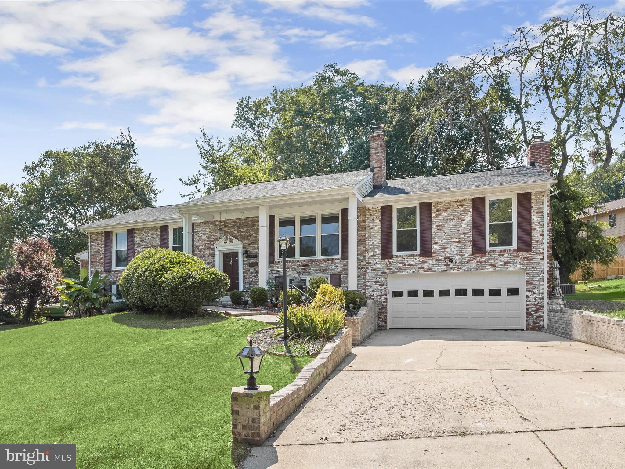 Welcome to this stunning brick-front home on a desirable corner lot, spanning over a quarter-acre. This beautifully renovated residence offers five bedrooms, three full baths, and a versatile lower-level in-law suite or apartment. The home is filled with natural light from large bay windows, creating a warm and inviting atmosphere. Step into the living room, where hardwood flooring and crown molding enhance the elegant ambiance. The adjacent dining room provides a seamless flow between the kitchen and living areas, perfect for entertaining. The renovated kitchen features soft-close cabinetry, a tile backsplash, an island, a pantry, and stainless steel appliances, including a gas range. The expansive family room is a cozy retreat, complete with built-in bookcases and a pellet stove with a brick surround. The primary bedroom offers a getting-ready vanity and sink, a walk-in closet, and an en-suite bath with a floor-to-ceiling tiled shower. Two additional bedrooms and a full bath complete the main level. The lower level is a versatile space, featuring a recreation room with a second fireplace, two bedrooms, a full bath, and a laundry room. With three walkouts, this level is ideal for guests. Outside, enjoy the tiered deck and patio, perfect for outdoor gatherings. The nearby community pool offers membership opportunities for summer fun. This home is conveniently located near US-301, I-495, MD-5, Joint Base Andrews, National Harbor, Washington DC, shopping, parks, and more. Experience the perfect blend of comfort, style, and convenience in this exceptional home.