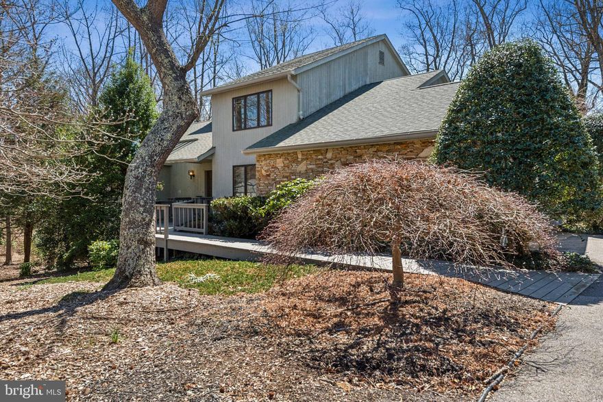 New Listing! Annapolis - Water Privileged/Water Access - Location, Location, Location! Custom Contemporary on almost 1 acre in the water oriented community of Eatons Landing which offers community access to Crabb Creek off the South River with an estimated 6' MLW.  Water access includes: Community Pier, Kayak Launch & Storage, Mooring Ball Privileges, Transient Boat Dockage, Fishing and beautiful views all with a low $300 per year HOA. This gorgeous home is strategically located in a small enclave of homes with an estate-like setting surrounded by large homesites naturalized with lovely greenery, trees and nature yet just minutes away from the popular, bustling Historic Downtown waterfront area with local restaurants, pubs, galleries and the infamous Naval Academy. Offering a total of 4 bedrooms and 3.5 baths with an open spacious floor plan this home features gleaming hardwood floors, tall vaulted ceilings, skylights, large oversized windows and an expansive 2 level wrap around deck with 2 car side entry garage. The Main Level is comprised of a large Great Room with 2 story ceilings and showcased with a stunning floor to ceiling stone fireplace with custom mesquite wood mantle, wet bar, and sliding glass doors to a wrap around deck with wooded views. There is a front room off the Foyer formally used as a dining room but purposed now as a convenient home office, Kitchen with ceramic tiled floors, Island and expansive counter space and sunny breakfast room with skylights, large windows and serene views of the backyard and large laundry room/mudroom down the hall. The Primary Bedroom is also located on the Main Level  boasting wood floors and generous dimensions of 18' x 19' with a 7' x 9'  cedar lined walk-in closet, romantic brick fireplace, sliders to the wrap around deck and renovated bath with modern, free standing soaking tub, double sinks and glass enclosed walk-in shower. The Upper Level is accessed by a beautiful oak staircase with balcony like overlook to the Great Room below  and leads to Bedroom #2 and Bedroom #3 each with hardwood floors and hall full bath with ceramic tile. This home is uniquely outfitted with two generously sized and easy to access walk-in attic spaces; one located off the staircase measuring approximately 9' x 33 ' and the second one accessed from Bedroom #2 and measuring 10' x 15' . The lower level is fully finished except for a 15' x 23' utility room/workshop with furnace, 2 water heaters, owned water conditioning equipment, sump pump and included wooden work benches. The lower level Family Room and 4th Bedroom with 3rd Full Bath and 3rd Fireplace are on this level which is actually above grade and has sliders to a ground level deck. The Family Room is an expansive yet cozy space with two year old carpet in a whimsical light plaid design with large windows  making the space sun-filled and bright and is ideal for recreational get togethers by the fire or a fun-filled space as a kids playroom. Off this area is a dedicated 15' x 15' Work Out room with sport rubber flooring. Finishing off this level is the 4th Bedroom with walk-in closet, full bath with separate large sunken tub and separate tiled shower stall with glass doors. This home comes in at 4122 finished sq feet and is on private well and private septic and has a heat pump. Currently the home is in the process of having the exterior professionally painted and should be completed in about a week.