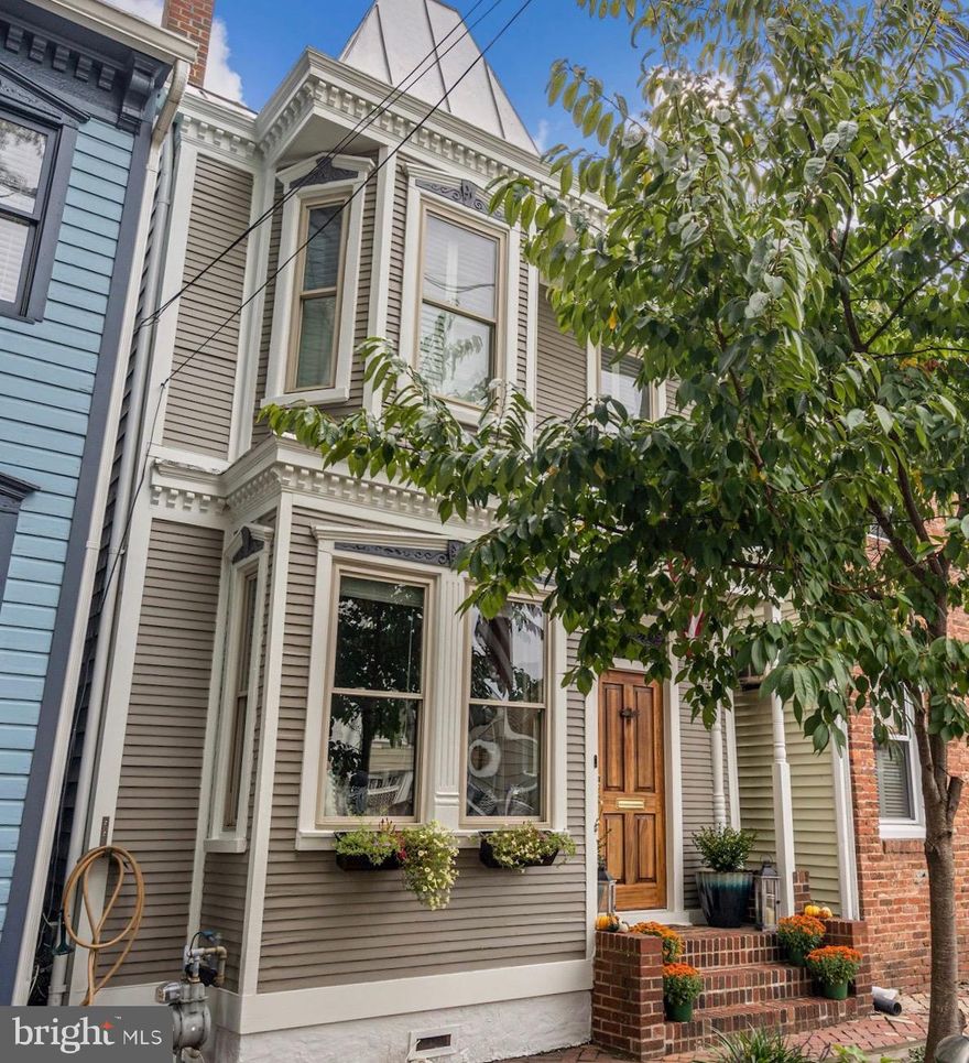 *Fabulous Price Reduction!* 119 N Payne Street is the perfect blend of Victorian Charm and Modern Amenities. This detached 3 Bedroom 2.5 Bath Townhome is located on one of the most picturesque streets in the heart of Old Town. This home offers two-levels of easy urban living. The foyer, with its original stained glass transom window, leads to a cozy living room with a large bay window, gas fireplace surrounded by custom built-in cabinets and bookshelves, hardwood floors, and crown molding. The formal dining room is accented with a beautiful chandelier, crown molding, chair rail, and hardwood floors. The gourmet kitchen features custom white cabinets, stainless steel appliances, granite counters and back splash with a kitchen island perfect for serving all your guests. The kitchen’s French doors lead out to an enchanting professionally landscaped garden, featuring its own delightful fountain and café lights, perfect for entertaining. The back portion of the garden can also be used as an off street parking space.  A quaint half bath completes the main level.
The Victorian staircase leads to the second level featuring original hardwood floors and three bedrooms with two full baths. The delightful primary suite features a fully renovated en-suite and private balcony, the perfect place for a morning cup of tea or coffee. The second bedroom features a bay window seat with storage along with custom cabinetry and a built-in workspace. The generously sized third bedroom and hall bath complete the upper level. 
Nestled in a prime Old Town location, 119 N Payne Street sits on a primarily residential street. Just steps from King Street and all the restaurants, boutiques, and novelty shops Old Town has to offer. A block and a half away is the Old Town Trolley Stop offering a free trip down King Street to Old Town’s Waterfront. Seven minutes to the Blue Line’s King Street-Old Town Metro Stop and 10 minutes by car to Regan National Airport.