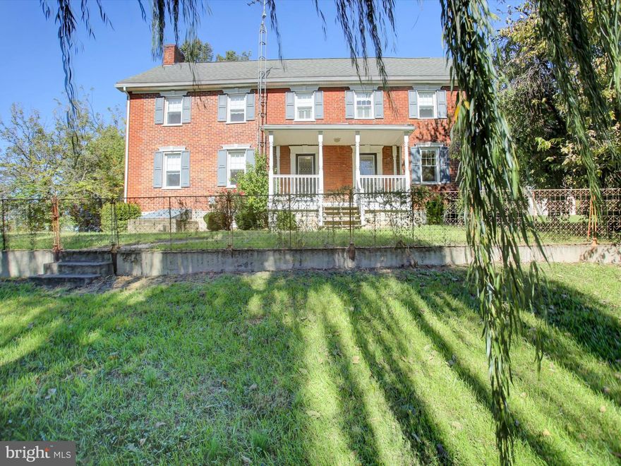 Here’s an incredible opportunity to own a beautifully updated piece of history. According to records, this charming farmhouse dates back to the Civil War era — and its character still shines through in the original exterior brick, decorative front fence, and impressive outbuilding with a slate roof and hand-hewn timbers.

Inside, you’ll find touches of historic charm blended seamlessly with modern updates. The original stair treads, deep window sills, and double staircase showcase the craftsmanship of the past, while the updates throughout make daily living a breeze. Gorgeous hardwood floors flow through the spacious main level, offering plenty of room for family and friends to gather.

The kitchen is a true highlight, featuring custom cabinetry with thoughtful details — pull-out drawers, sheet pan dividers, and a convenient spice rack system. A full bath and a large laundry room with built-in cabinetry complete the main level.

Upstairs, you’ll find three bedrooms and a full bath that connects both to the hallway and the primary suite. The bathroom features a double vanity and a separate toilet room. The primary bedroom boasts an impressive walk-in closet, while all bedrooms include generous closet space and overhead lighting. The third bedroom/flex room also includes a massive cedar closet with a handy laundry chute to the main level, plus access to the nearly finished attic — an expansive space just waiting for final touches to become an additional bedroom, hobby area, or storage.

Past updates include removal of horsehair plaster, new drywall, updated electric and plumbing, central air, and much more — blending historical charm with modern comfort.

Relax on the covered front porch and enjoy views of the stream, mountains, and the original family barn next door. The backyard includes a large shed perfect for a mower, workshop, or storage.

This home gives you the rare chance to own an incredible farmhouse without waiting for new updates. Come see for yourself how beautifully history and modern living come together here!