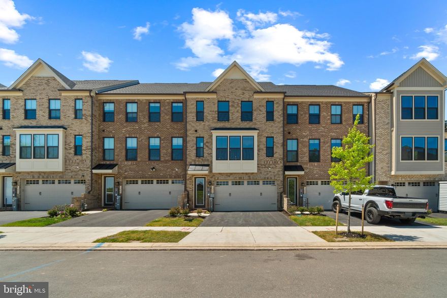 Stunning Colonial-style townhouse offering 3 bedrooms, 3 full bathrooms, 1 half bathroom, and 2,857 finished square feet in sought-after Longview Ridge. Built in December 2025 by NV Homes, this like-new residence showcases high-end finishes, thoughtful design, and a beautifully appointed interior throughout. The McPherson Grand floor plan features a bright, open-concept layout ideal for both everyday living and effortless entertaining. // From the moment you step inside, the home offers a sense of space, light, and modern comfort. The fully finished entry level begins with a welcoming foyer that opens into a spacious recreation room with walk-out access to the backyard, set against a private wooded backdrop, along with a full bathroom that adds flexibility for guests or additional living space. This level also includes a convenient staircase landing with built-in storage and access to the two-car garage. // Upstairs, the main level unfolds into a seamless open living area accented by gleaming luxury vinyl plank flooring throughout. A spacious great room flows into an expansive dining area with direct access to a covered balcony overlooking peaceful wooded views. The adjacent eat-in kitchen serves as the home’s centerpiece. Designed with both style and function in mind, this chef’s kitchen features a large center island with breakfast bar seating, pendant lighting, granite countertops, stainless steel appliances, including double ovens, dark shaker-style cabinetry, a crisp white subway tile backsplash, and a pantry. A second access point to the balcony enhances indoor-outdoor living and offers additional space to enjoy the surrounding scenery. // The upper level offers three comfortable, carpeted bedrooms, two full bathrooms, and a centrally located laundry room for added convenience. The owner’s suite provides a private retreat with a spacious walk-in closet and an elegant ensuite bath featuring a double vanity and an oversized shower with spa-inspired finishes and Kohler® fixtures. // Additional highlights include four-car parking with a two-car garage and a private driveway, as well as nearby guest parking and unobstructed green-space views from the front of the home. Ideally located just minutes from Hunt Valley Towne Centre, this home offers easy access to shopping, dining, and entertainment. The property also includes NV Homes’ comprehensive builder warranty, with one-year coverage on materials and workmanship through December 2026, two-year coverage on major systems, and a ten-year structural warranty, offering added confidence and peace of mind.