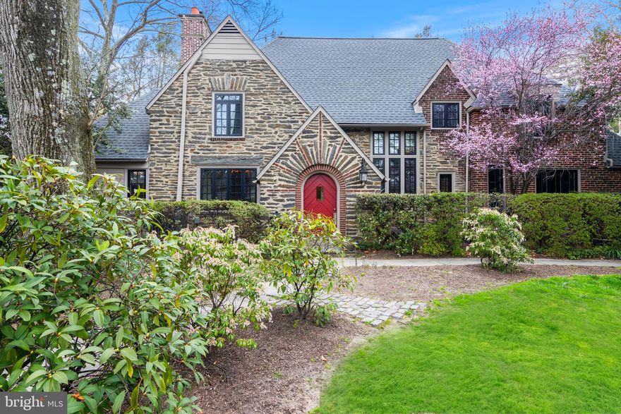 Just listed: A gracious 4-bedroom, 4.5 bathroom stone and brick Tudor home located on one of Swarthmore's most coveted streets. This iconic home is brimming with beautiful architectural and ornamental elements typical of the Tudor style, including an oversized arched entrance, steep pitched gable roof, and high-quality materials throughout.  Upon entering, you'll be greeted by a charming vestibule featuring one remaining original classic leaded window - all of the others in the home have been replaced - and natural wood doors. The stunning renovated kitchen boasts beautiful soapstone counters, custom painted cabinetry, stainless steel appliances including a Wolf range, a large center island, classic subway tile, and a large picture window overlooking the lovely grounds. There is also a gorgeous custom crafted built-in hutch with glass cabinets and tremendous storage! Adjacent to the kitchen is a fabulous family room addition with gorgeous hardwood floors, a dining area, double access to the amazing screen porch with a vaulted wood ceiling, a side door entrance with mudroom, and a lovely stairwell to the basement. The ceramic tiled basement features a large laundry room with sink and ample storage. In a separate room is a finished area - perfect as a playroom or gaming room - and there is still plenty of unfinished space for storage!  On the other side of the family room is the "favorite" room - an intimate den with custom built-in bookshelves, perfect for a home office or quiet sitting room.  A charming powder room is conveniently located right outside of this den. The opposite side of the kitchen leads to a gorgeous living room/dining area featuring a beautiful fireplace with a natural wood mantel, classic tile surround, and matching tile hearth. French doors lead from this room to the outdoors, onto one of the two stone patios,  creating a fabulous indoor-outdoor flow for entertaining and everyday living.  Just beyond the living room, you'll find French doors leading to a beautiful sunroom with an exposed stone wall, bead-board ceiling, and fabulous wallpaper. Currently used as an office and exercise room, this room also has a door leading outside.
The stunning staircase with rod iron railing and large picture window leads you from the kitchen to the equally wonderful second floor. At the top of the landing is a bedroom with a large walk-in closet and en suite bathroom. Just down the hall is a second bedroom with an en suite bathroom that also has a door to the hall. In its own separate area is a hallway leading to the renovated primary bedroom with a wall of custom built-in closets, an additional closet, and a beautiful large en suite bathroom with two vanities with granite, a glass stall shower, and a clawfoot soaking tub.  An additional staircase was added leading to the wonderful third-floor fourth bedroom with a separate full bath.  It is so unique and luxurious to have a dedicated bathroom for each bedroom! In addition to the wonderful layout and functionality of this home, the renovations have included high quality materials which are evident throughout including the hardwood floors, replacement windows, a new roof and the materials used in the stunning kitchen and lovely bathrooms renovations. The outdoor space of this home is equally impressive and includes two fabulous stone patios in addition to the screen porch and lovely hardscaping in the front as well. There is also beautiful landscaping throughout the property and a completely charming shed (being sold as is) adding to the overall delightful aesthetic.  This house's location is unparalleled - close to everything Swarthmore has to offer, including the SEPTA station, Swarthmore's restaurants and coffee shops plus easy access to other favorite retail nearby like Starbucks, Martindale's Natural Food store, and more. The convenience of access to major roads into Philadelphia and Wilmington could not be easier! This home is truly an exceptional one in every way!