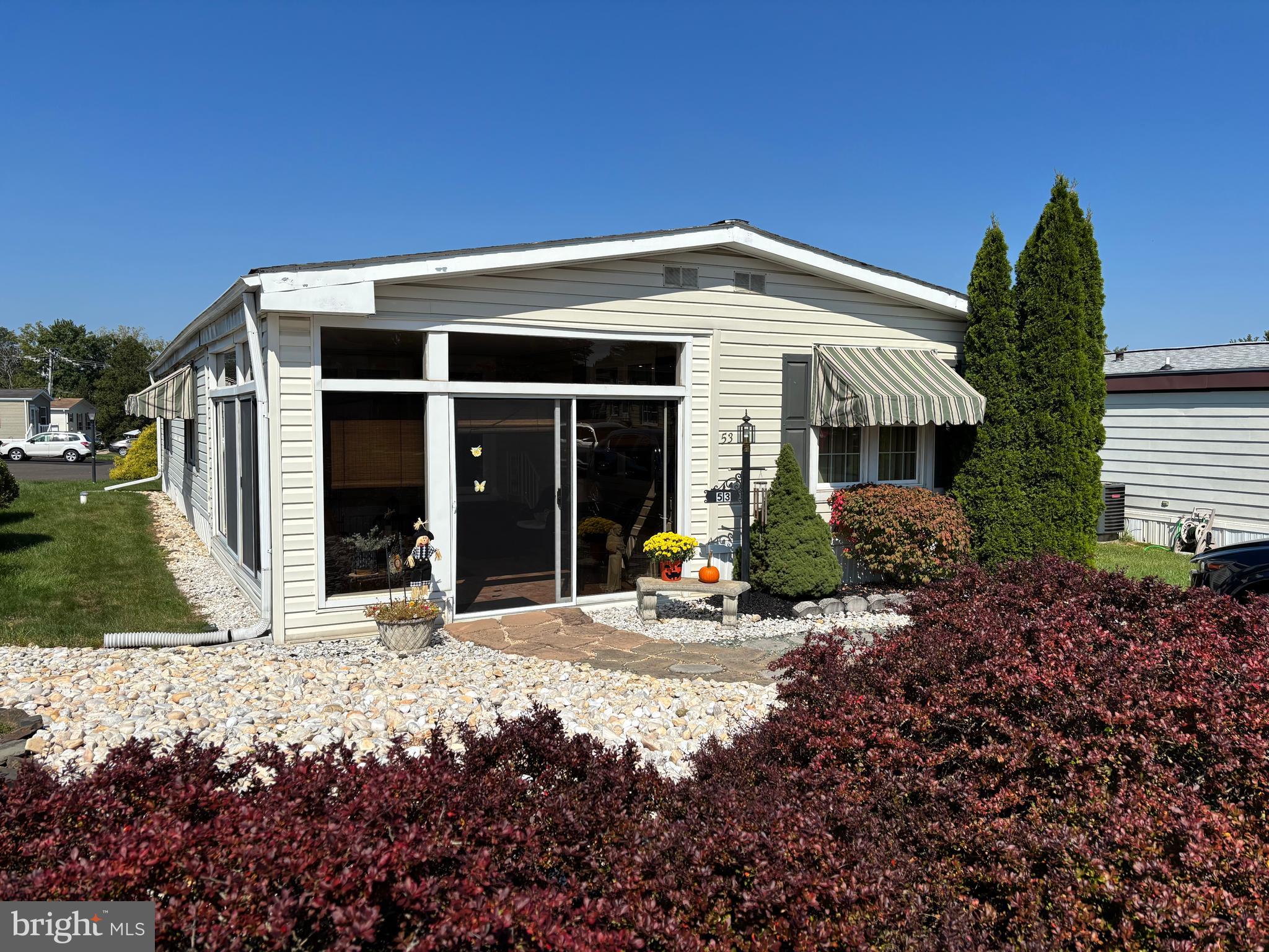 Welcome to this lovely, move-in-ready, 2-bedroom, 2-bath home, featuring impeccable charm that will give you a 'home sweet home' feeling upon entry. Park directly in front of your home, which has been professionally landscaped for your convenience, and step into an enclosed front porch with tile flooring and warmed by the morning sun. Even in the late fall/early winter months, this room remains toasty while you sip your coffee and take in the activities right outside your door. The spacious living room is open to the roomy kitchen and dining area. A convenient laundry room is just off the dining area that can be concealed when not in use. The open concept kitchen comes with white cabinets, white appliances, laminate countertops, a double sink with overhead pendant light, and a stainless-steel goose-neck faucet. Just off the dining area is a huge Florida room with tile flooring and an overhead fan, great as a retreat after a full day. Step outside through a sliding glass door to find an open stone patio and a storage shed to hold your gardening tools. The two generously sized bedrooms with cedar-lined closets are on opposite sides of the home and allow privacy when entertaining guests or family members. Each bathroom includes tile floors with updated vanities and shower stalls. This home also comes with a new front door and sliders, and newer carpets in the bedrooms and living room. Don't wait on this one. Schedule your appointment soon!!