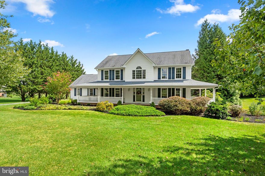 Classic  custom colonial set on a level 1.25 acre landscaped homesite in Sun Valley is defined by its welcoming wraparound porch, and a warm 2-story hardwood foyer. Inside you find beautiful LVT flooring, a light-filled main level hosting a formal dining room adorned with crown molding, chair rail trim, and a ceiling medallion, a bedroom or study, and a family room centered by a wood burning fireplace flanked by custom built-ins with a glass slider stepping to low maintenance deck and screened gazebo. Raised panel white cabinetry anchors the sunlit country kitchen boasting quartz counters, stainless steel appliances, a planning desk, and a bay windowed breakfast room overlooking a bright family room. Upstairs is an owner's suite highlighted by a walk-in closet, a lighted ceiling fan, and a garden bath displaying a double vanity, a separate shower, and a bay area jetted tub. Downstairs you find a walk-up basement ready for your creativity and best design ideas. Conveniently located minutes from downtown Westminster, Clearview Air Park, commuter routes 26, 27, 97, shopping, commuter routes and more!