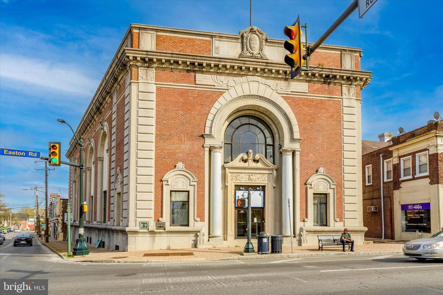 This prime building was built in 1920 and used as a bank for 102 years, it is now ready for a new "chapter". The building includes  it's own 48  space parking lot and a side entrance.  There are also 50 municipal spaces just behind and adjacent on Bickley.  There is a drive through window too.  The first floor is vast, open and  has high ceilings.  The  large windows  flood the space with natural light.  The Vault makes a beautiful focal point and is bigger than some rooms. There are offices, a kitchen and bathrooms on the first floor. This would make a great restaurant, bank, retail space. event hall, church, art gallery; your imagination is your limit.  Or develop it into something totally different.
The second floor on the south end has bathrooms, and an office space that is currently occupied by a tattoo parlor. The third floor has a kitchen and large office suite that is currently vacant.  There is a closet adjacent to the stairs that could be an elevator shaft as there is one on each floor. The North/front end of the building on the second floor has a large office and a conference room with bathroom that overlooks the Septa station that is across the street.  Located in the MU1 Zone.