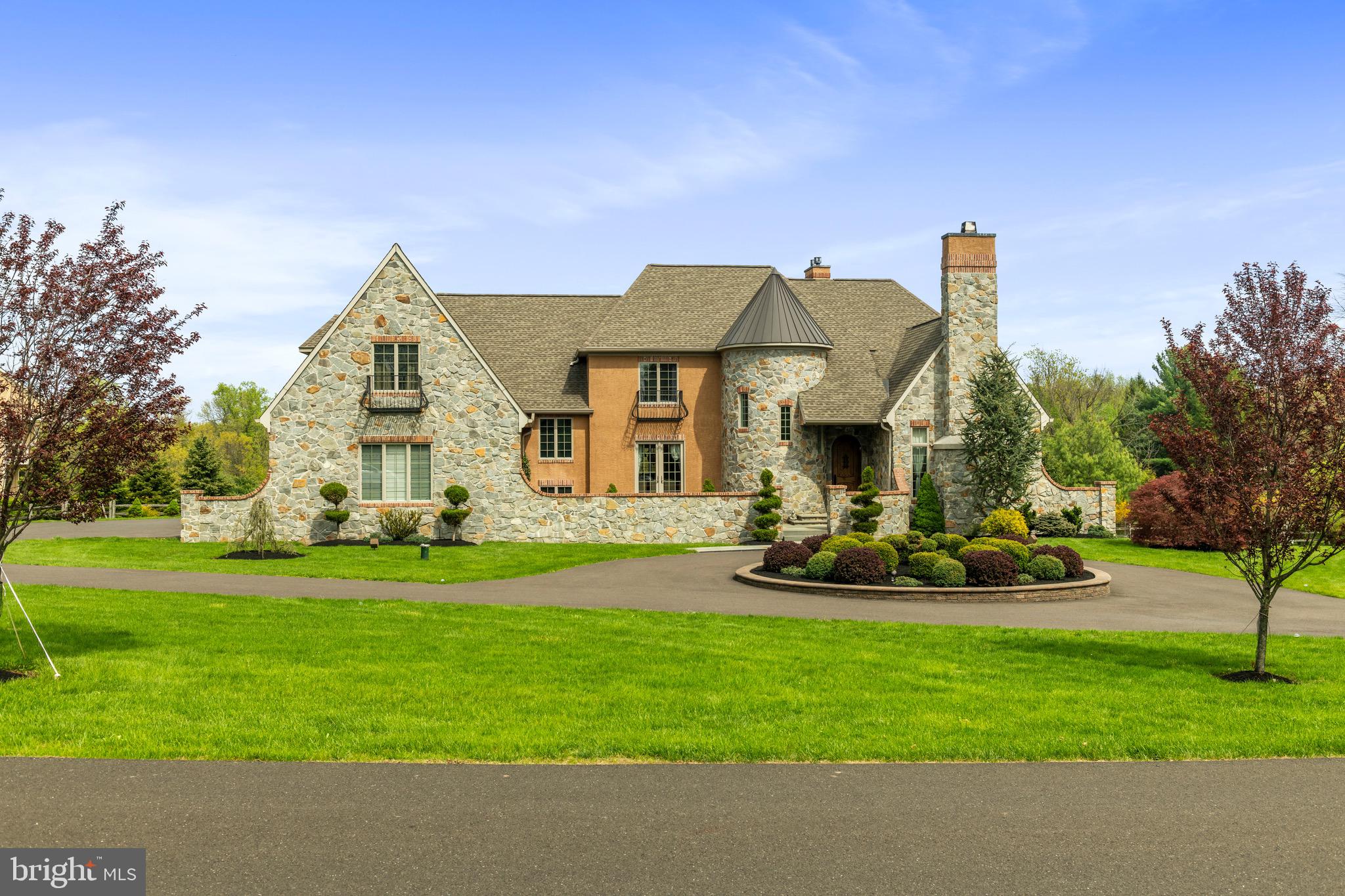Custom Luxury Home located in Stoneymead, one of the most prestigious neighborhoods in Buckingham Township, Bucks County. Enter this French Tudor complete with turret and rustic alder door, and a courtyard straight out of Tuscany. Once inside the welcoming foyer you will notice the spiral staircase and a French door courtyard walk out in the dining room. The living room has a natural stone 18 ft. fireplace and adjoining study with wet bar. At the heart of the home is the Italian limestone floored kitchen complete with a Bertazzoni 6 burner stove and a large island with exotic quartzite. Next to the kitchen is a breakfast room, a family room separated by a stack stone see-through gas fireplace and access to a large composite deck which over-looks a bucolic gentleman’s farm. Upstairs there are 5 bedrooms and 4 bathrooms. The master suite has a gas fireplace, deep cast iron tub, large walk-in stack stone shower, 2 dressing rooms and sitting room. The lowest level has a completely finished 2000+ sqft. walk out basement with travertine floors, a 1920’s themed bar inset with an 1841 antique post office, wine cellar/grotto, fitness room, office, pool table area and a full bathroom. The French doors lead out to the bluestone patio with salt-water spa and pool. Built with some of the finest specimen stone countertops and floors, complete with an oversized 4-car garage and whole house generator. Many panoramic views throughout the house on this flat 2.32-acre property with many updates since it was built in 2012.