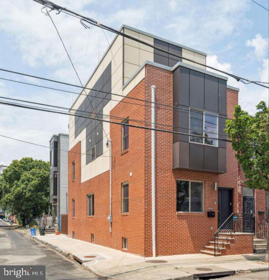 Welcome to a striking 17-foot-wide corner residence that blends sophisticated design, generous scale, and elevated city living just moments from the energy of Frankford Avenue in the heart of 19125. This 3-bedroom, 3-bathroom home is bathed in natural light thanks to its coveted southern exposure, creating a bright and airy ambiance throughout the expansive open-concept living and dining spaces.

Designed for both refined entertaining and everyday comfort, the gourmet kitchen is a true showpiece, featuring veined granite countertops, premium stainless steel appliances, a statement center island with seating, a built-in wine refrigerator, and abundant soft-close cabinetry. Just beyond, the spacious backyard offers a rare private outdoor retreat.

The oversized finished lower level adds exceptional versatility with soaring ceilings, designer tile flooring, and a full bath-ideal for a media lounge, guest suite, fitness studio, or executive home office.

On the second floor, two bright and generously sized bedrooms are thoughtfully positioned on opposite ends of the home, separated by a beautifully finished full bath and a conveniently placed laundry area.

The entire third floor is devoted to a stunning primary suite designed as a true sanctuary. This luxurious retreat features an expansive walk-in closet and a spa-inspired bath complete with a glass-enclosed walk-in shower, dual vanity, and a sleek freestanding soaking tub.

Crowning the home is a private rooftop deck with breathtaking, unobstructed views of the Center City skyline-an exceptional setting for morning coffee, sunset cocktails, or effortless entertaining under the city lights.

Perfectly situated near Frankford Avenue and in the heart of Fishtown, this exceptional residence places you steps from acclaimed dining, boutique shopping, vibrant nightlife, and convenient transit. This is a rare opportunity to experience modern luxury in one of Philadelphia’s most dynamic neighborhoods.