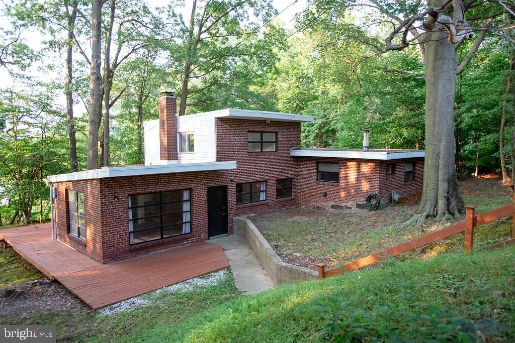 Urban Chic Meets Mid-Century Modern Design in this one-of-a-kind, thoughtfully designed home with Wright-inspired elements. Set back from the road and surrounded by mature landscaping, this property offers a rare opportunity for design lovers seeking something truly unique. The open floor plan features a floor-to-ceiling double-sided brick fireplace, wraparound deck, and a spacious yard that provides privacy and connection to nature. The first floor includes open living and dining space, two bedrooms, a fully updated bathroom, and an eat-in kitchen. Upstairs, a spacious primary suite with a full bathroom offering peaceful separation and comfort. Recent updates include new flooring in all bedrooms, fully updated bathrooms with tile flooring and surround, and fresh interior paint. If you’ve been searching for a home with architectural soul, multifunctional space, and modern comfort—all in a convenient suburban setting—1092 Tyson Avenue is calling.
Some listing images have been virtually staged to illustrate the property’s potential.