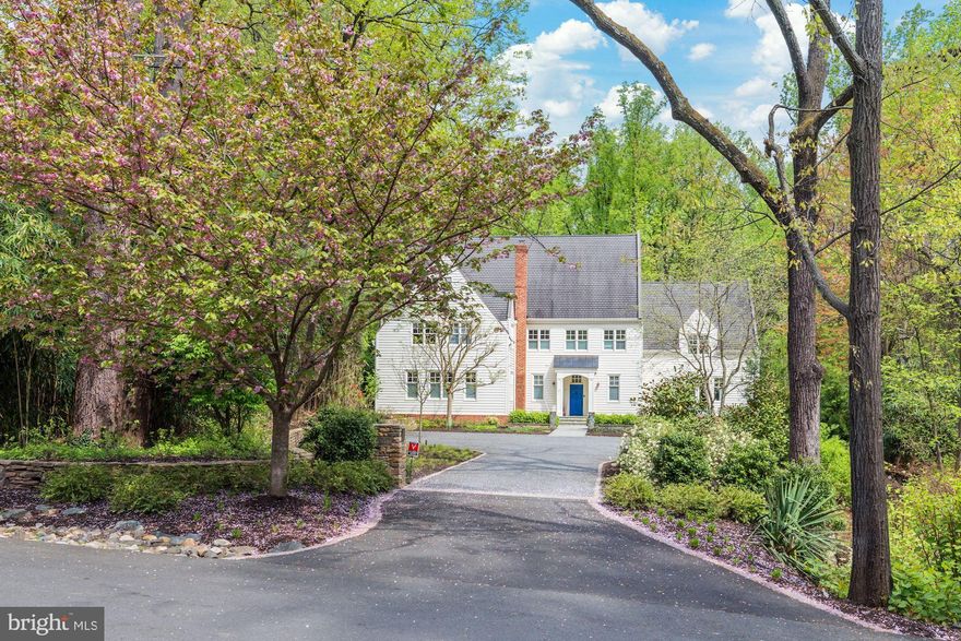 Landscaped solitude meets thoughtful design in this Franklin Park haven. Sited on a 1.11 acre lot adjacent to parkland and reminiscent of a country lane with ample parking, this elegant, modern interpretation of an English country house encompasses approximately 8,339 SF+/- of living space, including 6 bedrooms, 5 full and 2 half bathrooms. A 2019 designer kitchen with a bifolding glass wall that opens up to an incredible terrace with substantial hardscaping and landscaping that includes terraced cocktail pools with waterfalls, a bar with built-in grill, shade sails covering an outdoor lounge are, a fire pit, a bucolic, flat lower yard and private play area to complete this idyllic property.  The home’s rooms are graciously sized inviting form and function that simultaneously caters to large entertaining and comfortable cozy family living. Exquisite views pour in throughout the first level and are beautifully framed by 10’ ceilings, large windows, and the bifolding glass wall as well as multiple French doors.  Just inside the front door, a mosaic tiled entry hall with generous walk-in coat closet connects the home’s main living areas. The thoughtful layout of the rear courtyard encourages indoor/outdoor entertaining both from the expansive and bright family room with built-ins to the designer kitchen with bifolding glass wall (including a full-wall screen) that opens to the sweeping bluestone terrace with multiple lounges and outdoor seating areas. In the kitchen, modern cabinetry presides with designer tile and lighting selections, gourmet appliances including a new built-in espresso machine, and a substantial quartz island with waterfall edge and pendant lighting. Adjacent to a 2nd island is an intimate breakfast area offset by the central dual-sided masonry wood-burning fireplace. The breakfast room and kitchen windows offer views of both sides of the home’s bucolic grounds. The kitchen’s front French doors open to an expansive, fully fenced kitchen-garden with fruit and vegetable patches—truly a cultivator’s dream. The formal salon with a large bar, gracious formal dining room, living room and powder room complete the first level.  Tasteful accents like gently dormered windows bring charm to the home’s upper level, where a serene primary bedroom suite—complete with large private dressing area, sitting area with custom closet built-ins that opens to primary bath with rustic tumbled stone tile and countertops—is the perfect place to unwind.  Four bedrooms, two with renovated ensuite baths and two with individual toilets and sinks but share a bath all centrally meet. A chic laundry room with new washer and dryer and expansive hall linen closet complete the generous upper foyer. The loft level offers a sophisticated, and extremely private library with a stunning ceiling treatment, custom built-ins and designer finishes. Lastly, there is a sixth bedroom and full bath, and a bonus room leading to more unfinished storage space. The lower level adds 1,774 SF+/- of extra living space, accommodating garage access large mudroom, a mirrored home gym, incredible custom stone temperature controlled wine cellar and tasting room with slate floors, walls and tiled barrel-pointed ceiling and custom wine racking and displays. An ample recreation room and powder room round out the space. The lower garage driveway includes a lit basketball hoop and garden shed. Landscape lighting and irrigation have been recently installed, and a whole-house generator is included.   Sited beautifully in perhaps the most coveted spot in all of Franklin Park, a community known for its special combination of mature trees, charming rolling hills, and extremely convienent location which offers close proximity to the best that McLean and North Arlington have to offer, and is also ideally situated just minutes to the George Washington Parkway, 1-66, Tyson’s Corner, and the Capitol Beltway.