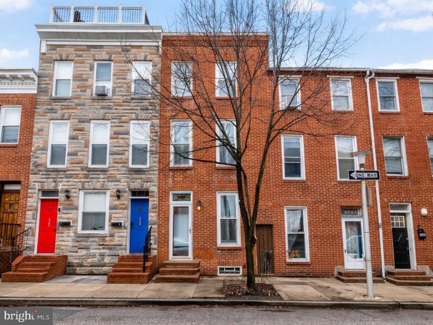 This spacious, open, and bright 3 bed, 2.5 bath rowhome is located on one of Federal Hill’s most desired streets - Riverside Avenue! Filled with charm and modern necessities, this renovated home features exposed brick, original hardwood floors throughout, and a coveted off-street parking pad. Step inside to a welcoming living room that flows seamlessly into a generous dining area - ideal for entertaining. An adorable powder room is tucked away beneath the stairs before you reach the gourmet kitchen that features stainless steel appliances, rich wood cabinetry, upgraded granite countertops, a custom tiled backsplash, and radiant heated tile floors. Just beyond the kitchen, a stunning bonus room showcases a dramatic two-story wall of windows, flooding the rear of the home with natural light and creating a truly unique living space. Upstairs, you will discover a large guest bedroom, a centrally located updated bathroom, the laundry closet, 3 full-sized closets, and a versatile third bedroom/den open to the bonus room below. The entire top floor is dedicated to the expansive primary suite, featuring exceptional closet space and an additional updated full bathroom. Head up to the rooftop deck to take in breathtaking 360-degree views of the downtown skyline, Inner Harbor, and iconic Domino Sugar sign. It’s the perfect vantage point for the Blue Angels airshow and 4th of July fireworks coming later this year. Located just steps from parks, restaurants, and shopping, plus easy access to I-95 and downtown, this move-in-ready Federal Hill gem offers the perfect blend of character, functionality, and city living. Schedule your private showing today before it’s gone!