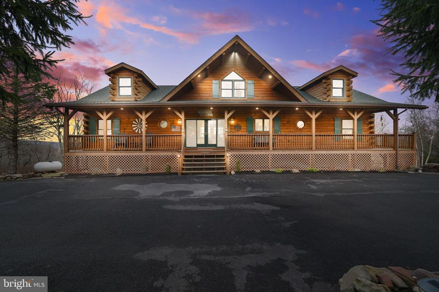 Welcome to your dream escape in the heart of the Poconos! This stunning 3-bedroom, 3-bathroom modern log cabin blends rustic charm with refined finishes across more than 3,100 square feet of thoughtfully designed living space. Nestled on a beautifully landscaped 2-acre lot, this home offers privacy, serenity, and panoramic views—including Blue Mountain on clear days! Step onto the expansive full-length front porch, or entertain in style on the over 850-square-foot back deck that overlooks the rolling valley—an ideal space for gatherings, dining al fresco, or simply soaking in the beauty of the great outdoors. The property features a circular driveway leading to a 2-car garage, wrapping around for effortless access. You'll also find a novelty pond, an organic garden, and a newer greenhouse—perfect for gardening enthusiasts and nature lovers alike. Inside, the wow factor begins the moment you enter through the sliding doors. The soaring ceilings and wall of windows in the great room immediately draw your eye to the spectacular views. Anchoring the space is a stately stone propane fireplace and a beautifully crafted mantel—this room is truly a showstopper. The eat-in kitchen features rich cabinetry, granite countertops, a stone-accented peninsula, and stainless steel appliances with gas cooking. Whether you're sitting at the peninsula or in the adjacent dining area, every meal comes with a view. The main floor offers two spacious bedrooms, an office, and two full baths, including a secondary suite with a luxurious soaking tub, stall shower, built-in dresser, and private access to the back deck—imagine waking up to breathtaking views every morning. You'll also find a laundry room and walk-in pantry conveniently located on this level. Upstairs, a sunlit loft space offers over 300 square feet of flexible living overlooking the great room. There is also additional access to wonderful storage space. Downstairs, the primary suite is your private retreat, complete with sweeping backyard views, a private patio, electric fireplace, custom luxury bath, and an oversized walk-in closet. This level also includes a smart artic entry from the garage - keeping the cold out on winter days and ample storage space throughout.  Craftsmanship shines in every detail of this unique home. Select furnishings may be included - ask for the list!  Don't miss this rare opportunity to own a one-of-a-kind mountain home with both style and soul. Schedule your private showing today!