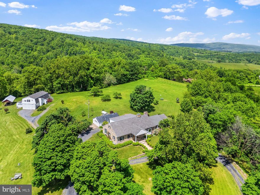 MAGNIFICENT VIEWS!!!! The stone residence is charming, the mountain views are magnificent!  Within minutes of Paris, Delaplane, and I-66, at an elevation of 1200’, the expansive views, in all directions, cannot be overstated. From inside the home, or from one of the terraces, or the lawn one can enjoy glorious sunrises, sunsets, and nighttime star gazing. Sharing a boundary line with the Thompson Wildlife Management Area, this property offers easy access to hiking trails, including the Appalachian Trail, an abundance of wildlife, and beautiful wildflowers. 

From Leeds Manor Road, the driveway divides. To the right a circular drive brings one to the front of the home, the driveway then reconnects and continues to the garage and the barn which has a spacious second-floor apartment. 

Upon entering this warm and inviting home one is surrounded by soft yellow walls and gleaming pine floors, which run throughout most of the home. The current owners have made significant changes throughout the home making it more open to the views and very inviting. To the left of the foyer, in the living room, shelving was added to the front wall, perfect for books and objets d’art. French doors were moved from the foyer side of the living room to the opposite wall, where a new opening was created, providing the option of using the existing second bedroom as a study. From the study/bedroom one has access to the back hallway with a full bath. Also from this hallway, one has access to the main level primary bedroom with walk-in closet and private bath. As the back hall intersects with the foyer there’s a powder room. 

From the foyer to the right, the hallway opens into the stunning gathering area of the home. A handsome stone fireplace is a focal point both from the hallway and the kitchen where a striking Alterna gas feature captures ones attention; above the fireplace is a stone mantle. The spacious kitchen features 2 work areas and a cozy breakfast area nestled in a bay window where one will want to linger and enjoy the views and the fireplace. 

This home features a lovely definition of rooms while still being open enough for an exceptional entertainment flow. A wall was removed from the kitchen opening it to the family room and the views. The wonderful family room features a beautiful stone fireplace, vaulted ceiling, and glass doors which lead to a covered stone terrace. The wall between the dining room and family room was replaced with a large mullioned window adding additional light and views. Completing the main level is a hallway which leads to the spacious mudroom/laundry room as well as the back terrace and yard.

The full second level features a bedroom suite with private bath, and three large walk-in closets, a sitting room and exterior door to a spiral staircase. 

The lower level offers additional space for hobbies, games, a pool table and potential for a guestroom with full bath. This level is semi-finished and has direct access to the back yard. 

Immediately behind the home is a one car garage with an attached potting shed. Behind the garage is a whole house automatic generator, and beyond the garage is a barn/garage with a full 1-bedroom apartment on the second level.

Beautiful year-round, flowering shrubs and trees  bring glorious color in the spring. The lawn is gently rolling and features boxwood, perennial gardens, terraced gardens and raised beds to the east of the home. This is a stunning property, where one can relax and breathe in the beauty.