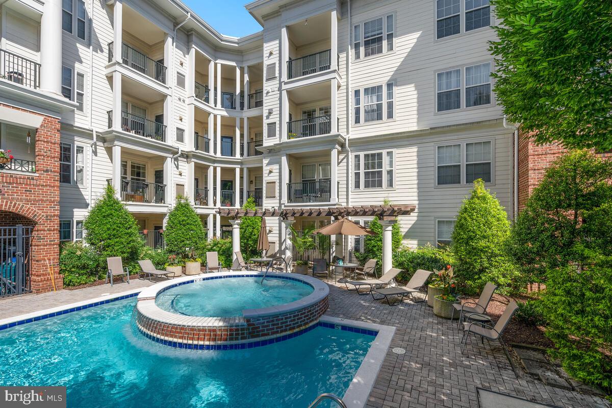 Great Location, Fabulous Amenities, 2 Garage Parking Spaces and Your Own Private Storage Room! This two bedroom, two bathroom condo features an open floor plan with architectural arches, crown moldings and high ceilings. There's also a convenient office nook - perfect for working from home, a spacious kitchen with updated appliances and updated flooring. The in-unit laundry room has a full sized washer and dryer. Both bedrooms feature updated ensuite bathrooms and large walk-in closets. Relax on your private balcony overlooking the pool! No noise from the Giant, busy roads, or public parking lots. In addition to the 2 assigned garage parking spaces, this condo includes a large, private 10' x 7' storage room located on the same level as the unit. Freshly painted in 2021. New HVAC in 2017. New HWH in 2018. It's a quick walk to nearby Kentlands restaurants, grocery stores, shops and entertainment. Building amenities include a lounge, two-level fitness center, movie screening room, wine tasting room, library and pool! What's not to love?