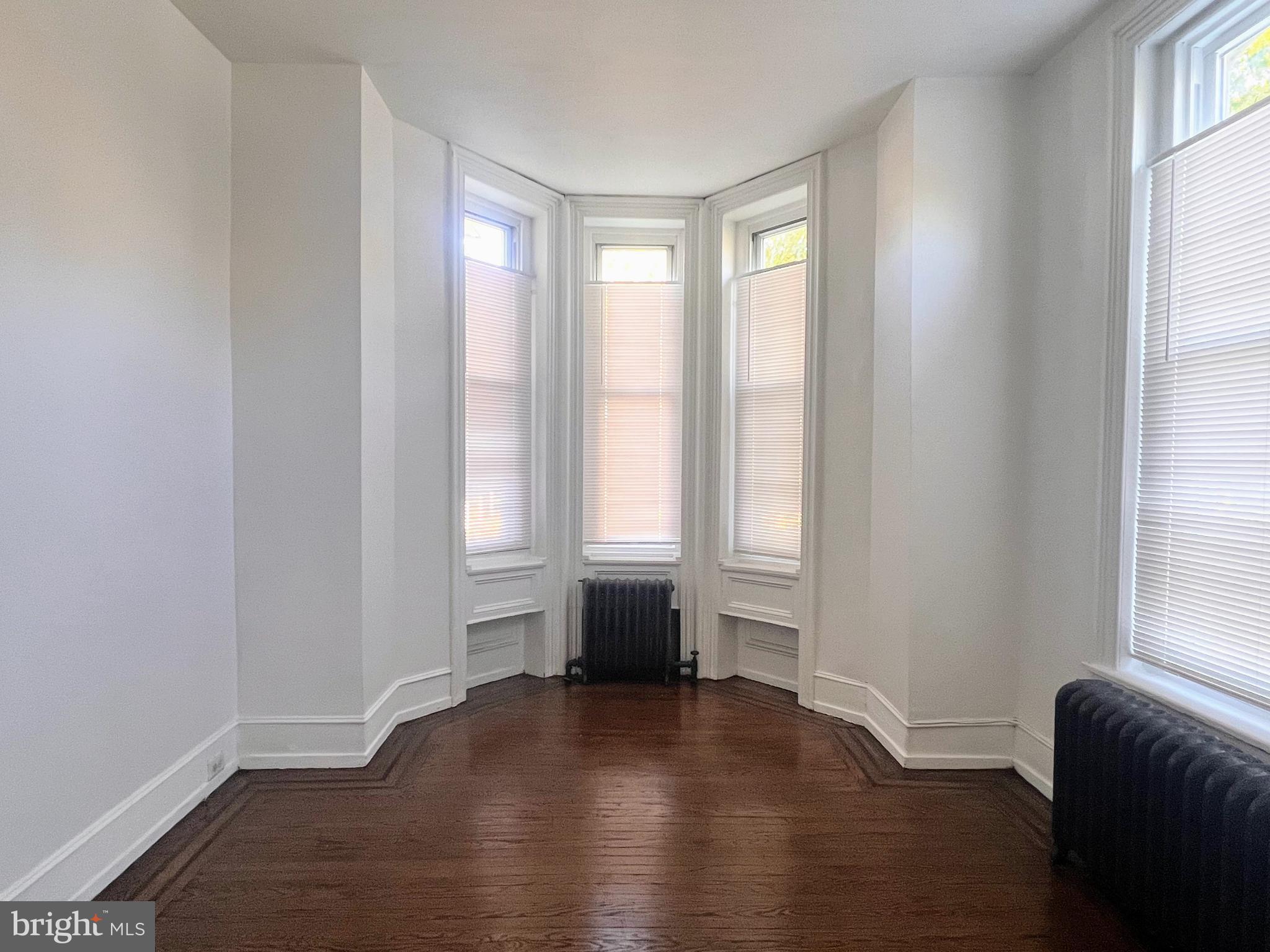 Large 3-bedroom apartment in handsome Victorian building now available for rent. This first floor unit, located on a great block in Germantown, is an exceptionally good value in today's market. Recently renovated, with a fresh coat of paint throughout, the unit is a clean and inviting space to call home. The grand living space features high ceilings, original woodwork, refinished oak hardwood floors with walnut inlay, and cozy radiator heat. To your right, you will see the open kitchen, with granite counters, stainless steel appliances, and plenty of cabinet space. There is also a breakfast bar to add a seating area, and a sunny space for a table under the bay windows. The kitchen also contains a stackable washer and dryer in the large closet. Continuing from the kitchen and down the hall, you will find a spacious full-tile bathroom with newer medicine cabinet and fixtures. There are 3 good-sized bedrooms continuing down the hall, each with brand new flooring and their own closet space. The third bedroom, on the back of the building, offers access to the outdoor space, which the tenant will be able to use for their enjoyment.