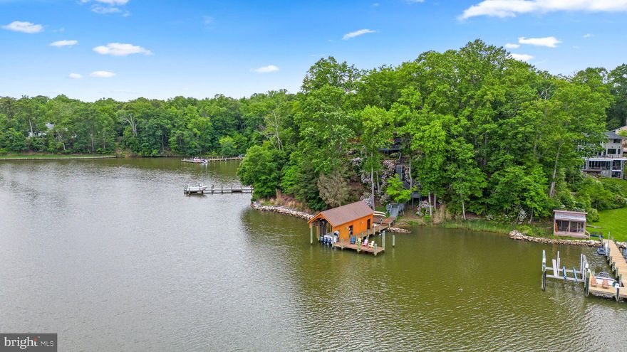 Private, contemporary waterfront retreat...Enjoy big water views of Broad Creek throughout the home. Wonderful location at the end of a cul de sac, the large .62 acre lot is just minutes from Downtown Annapolis. A coveted boathouse (50'x16') has been newly renovated and boasts a 20,000 pound boat lift- the perfect space to keep your boat covered all year long plus 212' of water frontage with 8' MLW at your private 65' pier, this property has so much to offer the boating enthusiast! Step inside the open concept, sun filled home with 4 bedrooms, 2 full plus 1 half bathrooms, an oversized 2 car garage and the most wonderful outdoor space designed with entertaining in mind! Great for cozy and quiet nights in on the 3 season porch or entertain family and friends hosting your favorite holiday or summer barbecues on the large, multi level deck overlooking the water, sip cocktails on the porch & enjoy evenings overlooking Broad Creek. You won't want to miss daily sunrises- the perfect way to start your day. Lush landscaping and hardscaping all along the property. The main level features a gourmet kitchen with granite counters and stainless steel appliances that opens to the 3 season porch. A dining room and living room with walls of glass and vaulted ceilings are the perfect back drop to the wooded lot with huge water views. You will also find a relaxing primary retreat with a spacious, private en suite bathroom with soaking tub, huge glass enclosed tiled shower and dual sink vanity, plus enormous walk in closet with built ins and bonus private laundry. Travel to the lower level where you will find 3 additional bedrooms and another full bathroom along with a second living room and mud room.

Home also features newer HVAC, Water heater, appliances & roof/skylights. Easy commuter access & close to shopping, dining & entertainment- this one will not last long. Schedule your private tour today!