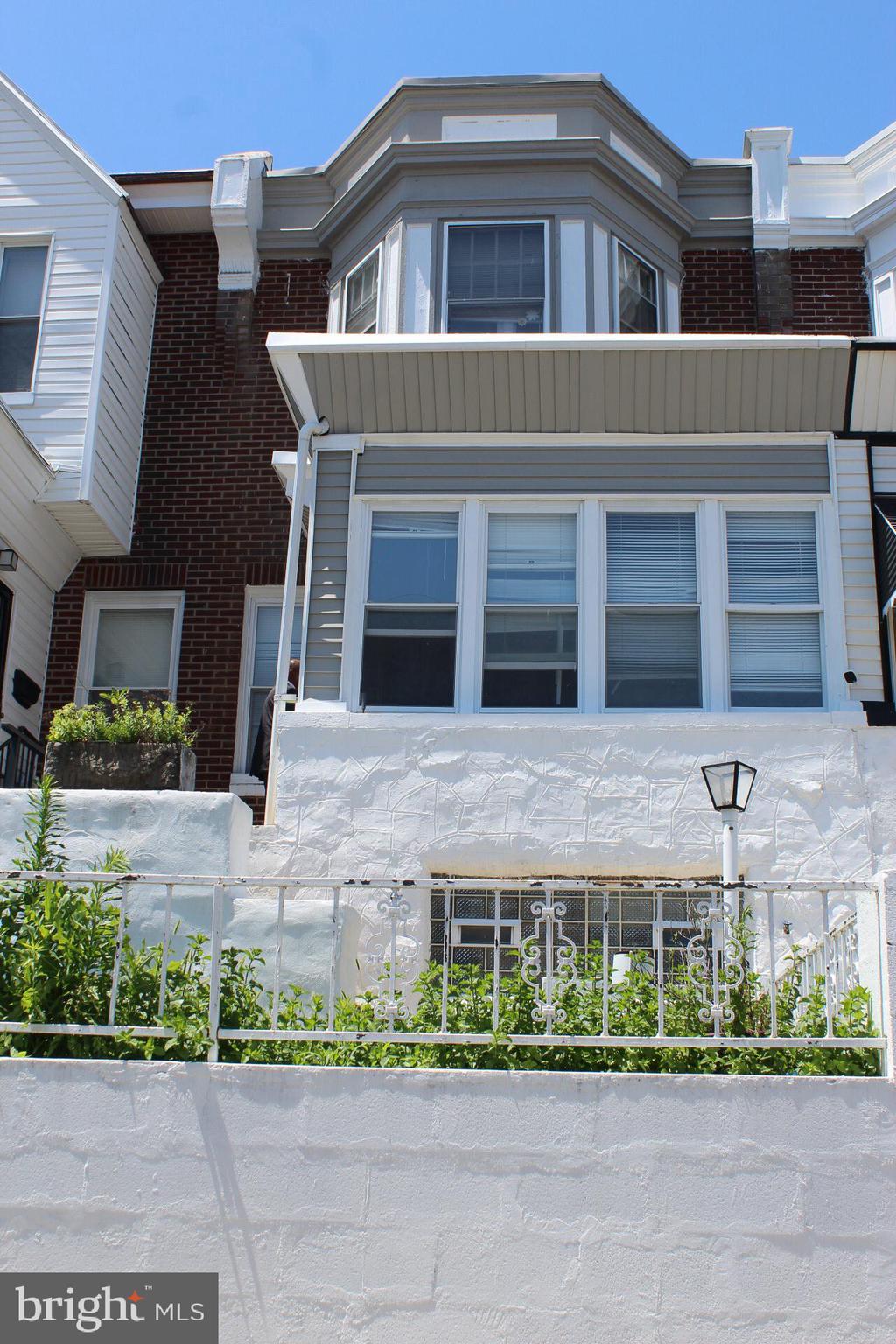 This elevated row home features a front patio accessible by steps. The entryway leads to a living room with a gas-line fireplace (unused by the current owner), a formal dining room, and a renovated kitchen that opens to a small connecting patio. The second floor contains three sizable bedrooms and a tastefully updated bathroom. The basement is finished, includes a full modern bath and laundry (washer & dryer), and the garage has been converted for extra storage with rear parking. All appliances are included except for the white refrigerator. The property is currently tenant-occupied on a month-to-month lease.