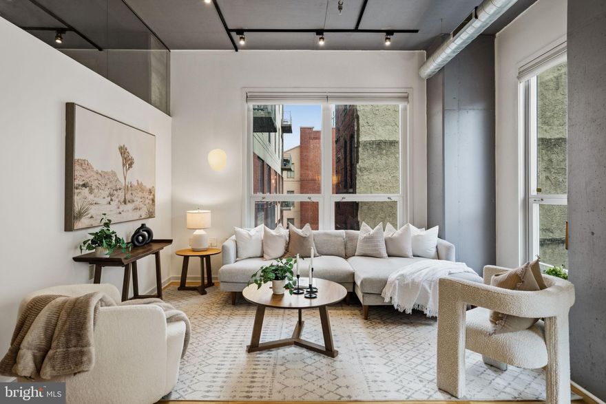 Welcome to 113 N Bread Street Unit 3A3, a sophisticated residence nestled within a gated enclave in historic Old City. This expansive three bedroom, two bathroom home offers over 1,500 square feet of beautifully designed living space, a private balcony, and coveted off street garage parking, an exceptional rarity in the city. An open, light filled layout is enhanced by oversized windows, rich hardwood floors, and custom built in shelving. Automated window treatments glide effortlessly along track systems, creating seamless comfort at the touch of a button. The kitchen is appointed with sleek cabinetry, a newer refrigerator, and a generous breakfast bar that anchors the space for both casual dining and entertaining. The living area flows gracefully to the private balcony, a tranquil setting for morning coffee or evening unwinding. The primary suite is a serene retreat featuring floor to ceiling windows, abundant storage, and a beautifully remodeled ensuite bath. The spa inspired bathroom showcases dual sinks with quartz countertops, a rain shower head, and striking hex tile flooring. Additional bedrooms offer ample closet space and bespoke built in desks, providing exceptional flexibility as guest accommodations, private offices, or refined work from home environments. Residents enjoy access to a shared outdoor courtyard and a secured underground garage.  Perfectly situated in the heart of Old City, this pet friendly residence is moments from fine dining, world class shopping, renowned cultural institutions, and vibrant nightlife. The home also offers convenient access to the University of Pennsylvania, Jefferson Hospital, Drexel campuses, HUP, CHOP, and major transit lines.