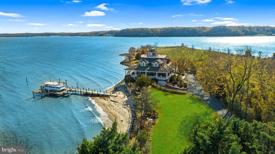 Welcome to Richlynd, the historic Pocahontas homeland on the shores of the Potomac River. This incredible property boasts an impressive 7 acre parcel, providing unrivaled privacy and serenity. Offering an unparalleled waterfront experience, the property is equipped with an expansive selection of boat docks and lifts plus a 1,300 foot pier. The home is a custom-built masterpiece, featuring over 6,800 SF of living space across 4 levels plus a sprawling 2,500 SF wrap-around covered deck designed for gracious entertaining that has space to host 150+ person seated dinner. The main level features a stunning foyer with breathtaking water views from the living room just beyond it. Both the living and dining rooms offer soaring ceiling heights and open to the wrap-around deck overlooking the water. In the spacious gourmet kitchen, you will find top-of-the-line appliances and room to seat 12 in the adjoining dinning area. A serene primary suite with covered deck access, beautiful water views, and a spa-like bath with hot tub complete the main level. Upstairs, five private bedrooms, each with their own unique water view and three full bathrooms provide ample room for all.  5-zone heating and cooling system, elevator to 3-floors, and a laundry rooms on 3-levels of the home ensure comfort and convenience. On the lower level you will find a large movie room that could double as an extra bedroom, an entire guest apartment with a bedroom, full bath, full kitchen, and living area, plus a 5-car garage and workshop. Immerse yourself in luxury with architecturally stunning details, large windows, and a floor plan that enhances the connection to the waterfront. Perfect for hosting events large and small with onsite parking for over 30 vehicles, Richlynd is the epitome of waterfront luxury – where the serene beauty of nature meets the refined elegance of a thoughtfully designed residence. Unquestionably, this property presents the rare opportunity to own a piece of waterfront paradise.