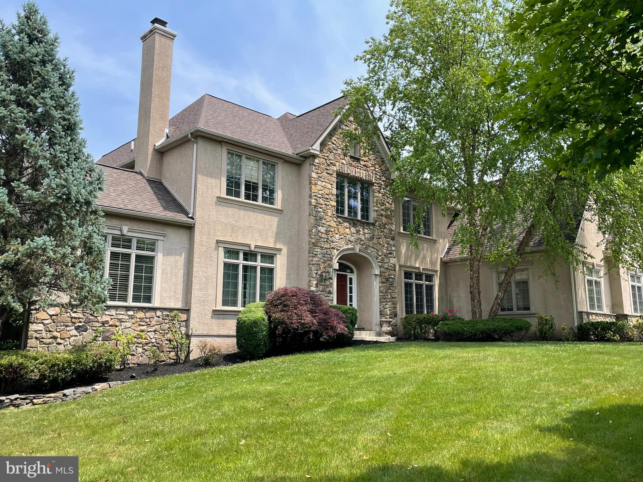 This stately 5 bedroom stone colonial is situated at the end of a quiet cul de sac at Springhouse Farm and offers versatile and open living spaces with hardwood floors and neutral tones. Upon entering the home, you are welcomed by the spacious 2-story foyer with turned staircase with wainscoting and millwork. The curved transom front door offers closets on either side. A cozy sitting room with beautiful details including a marble fireplace complimented with dentil molding and flanked by french doors. Step down to the tiled solarium that shares the marble fireplace with sitting room. The formal dining room is ideal for large gatherings. Make your way to the spacious gourmet kitchen with large granite island an inlayed butcher block and premium appliances, custom cabinetry and tumbled marble backsplash. The butlers pantry offers full wet bar with ice maker, dishwasher, wine fridge and beverage cooler. The breakfast room offers french doors providing views of the rear gardens, terrace and pool. The dramatic floor to ceiling stone fireplace is the focal point in the 2 story great room with inlayed carpet and huge palladian wall of windows. A private first floor study, large laundry area and two powder rooms complete the main level of this home. Ascend to the second level where you will find a sumptuous primary suite with arched transition to the sitting area and massive walk-in closet/dressing room. The primary bath offers a Jacuzzi tub, frameless shower, double vanity and water closet. Three additional bedrooms with large closets have private baths - en suite galore. Possibilities are endless in the third level with full bath and storage.
The day-light lower level is a spectacular entertaining space with a fitness room, billiard room, media room, sauna, craft room and beautifully finished full bath with seated shower. The full size oak bar includes a refrigerator, wall oven, dishwasher and unique copper sink.
But wait, there is more! The expansive terrace spans the length of the house featuring an amazing in-ground pool and spa. An outdoor kitchen provides a Fire magic Echelon grill, stove stop, 2 beverage refrigerators,
gas fireplace, TV, and granite bar that seats 8 comfortably and blends seamlessly in this great space. Nw roof 3/2023. Great location - close to the Springhouse Plaza and major routes for easy commuting in the award winning Wissahickon school district.
