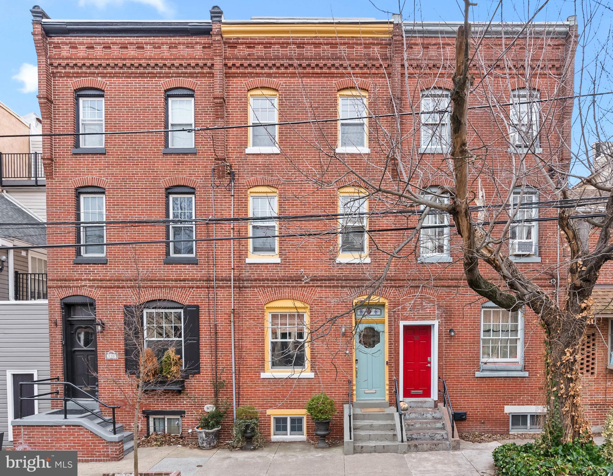 Standing as a testament to the expert craftsmanship and rich history unique to Philadelphia, 132 Bainbridge St is a meticulously maintained and updated residence with distinctive architectural details throughout, abundant space, and a new 4th-floor addition designed for entertaining. This one-of-a-kind home offers 4 bedrooms + a study, 2 full and 3 half bathrooms, a finished basement, a private patio, a roof deck, multi-zone HVAC, placement within the Meredith School catchment, and 1 year of prepaid parking. The historic, tree-lined streets of Queen Village lead to the exterior's towering brick facade. Inside, a vestibule guides you to a main level that feels open yet retains defined spaces. A bright window and a gas fireplace anchor the living room, where detailed molding and millwork are on display. Original red pine floors extend past an archway with hidden closets into a large dining room. Intricate stained glass adorns a powder room door by the center staircase. At the rear, the sunlit kitchen has generous cabinetry, a full suite of appliances, granite counters, a tile backsplash, and a breakfast nook overlooking the secluded patio. This private outdoor space is ideal for gardening or relaxing with a morning cup of coffee. Up on the home's second level, the cozy study off the staircase is swathed in rich wood, boasting a fireplace and bay windows. Down the hall is a full bathroom and two bedrooms. The third level is dedicated to the primary suite. The main bedroom, situated on one end, has plenty of closets, while the other end features a large, bright dressing room with a convenient laundry closet. The closet system in the dressing room could be removed by the current owner and sold as a 4th bedroom. At the center is a spa-like full bathroom with dual vanities, LED mirrors, a multi-jet shower, a jacuzzi soaking tub, luxurious tile throughout, heated floors, and heated towel racks. Topping off the home is an open, airy, and modern addition with a wall of windows at both ends and tons of space to host family and friends. There's a Juliet balcony at the rear, a powder room, a kitchenette, and accordion doors that open to a front roof deck with an outdoor kitchen for easy indoor/outdoor entertaining and views of the city and bridge, perfect for holiday fireworks. Bonus living space is found in the finished basement, along with a half bathroom, another laundry closet, and storage. Utilities include central a/c, forced air, radiator heat, gas hot water, and gas cooking. In addition to everything inside, this sought-after location earns a near-perfect Walk Score of 98! Top-rated restaurants, local shops, and popular markets line nearby South St and neighboring Old City. Entertainment along the Delaware River is steps away, plus stores like Target, IKEA, and Lowe's are a short ride. There's also easy access to public transit, I-95, and South Jersey. Schedule your tour today!